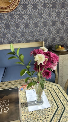A vase of pink and white flowers on an inlay table