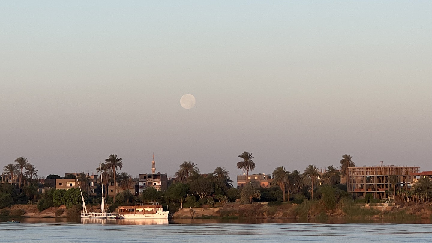 LUXOR, EGYPT. APRIL 2025.
The moon at sunrise on the Nile River in Luxor, as seen from aboard a riverboat.