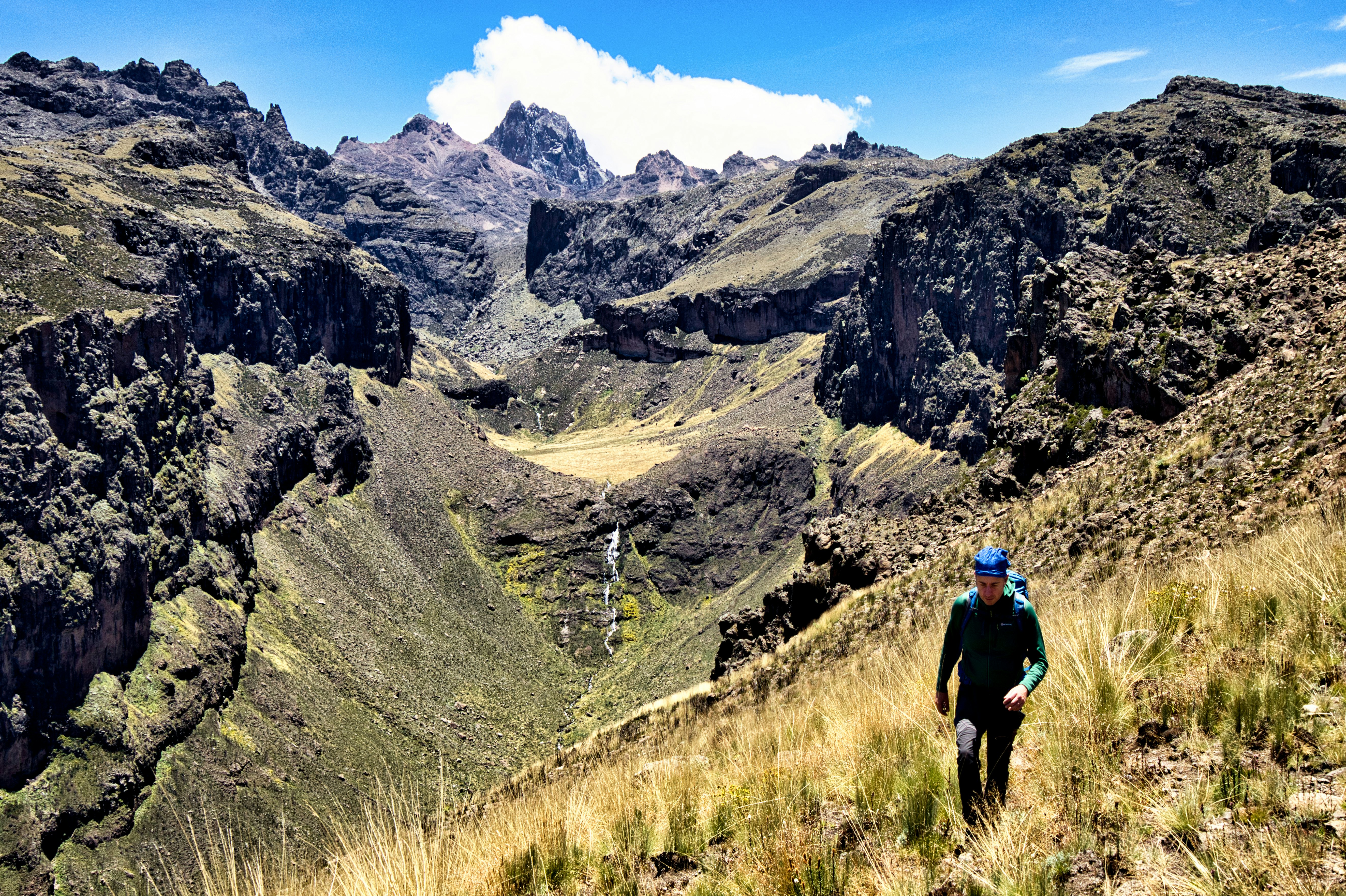 A man follows a mountain hiking trail.