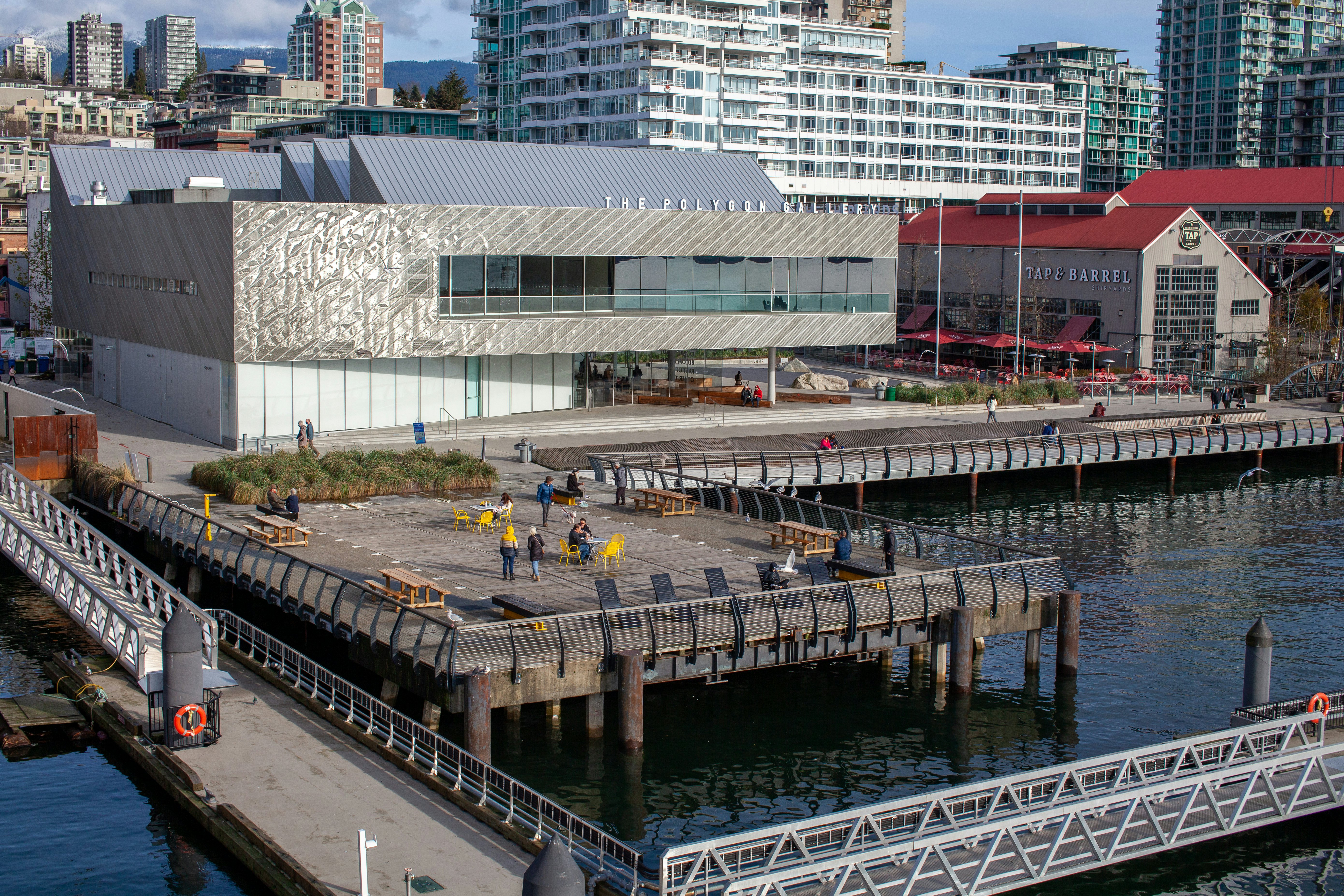 An aerial view of piers over the water in Vancouver, Canada, with a large brewery and gallery on the shore.