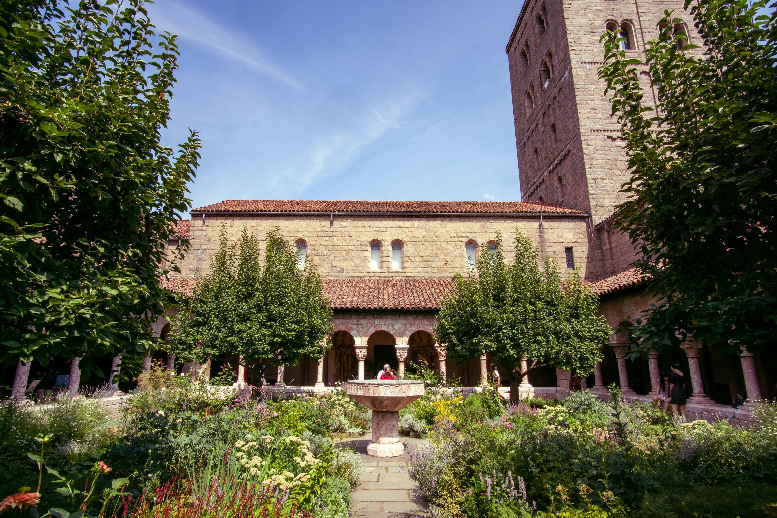 The gardens of the Cuxa Cloister, part of the Met Cloisters, with a few people in the background