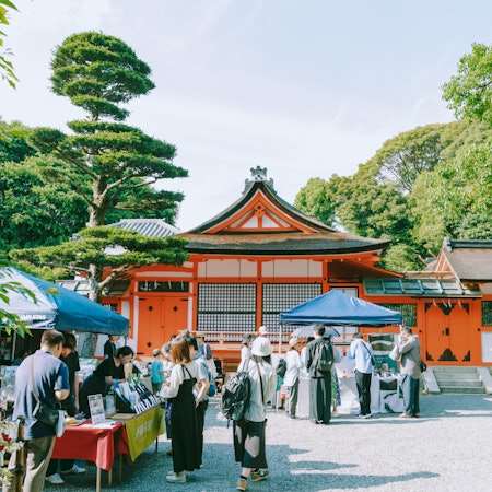 A pop-up tea shop stands at the entrance to a red-painted shrine in Kyoto.
