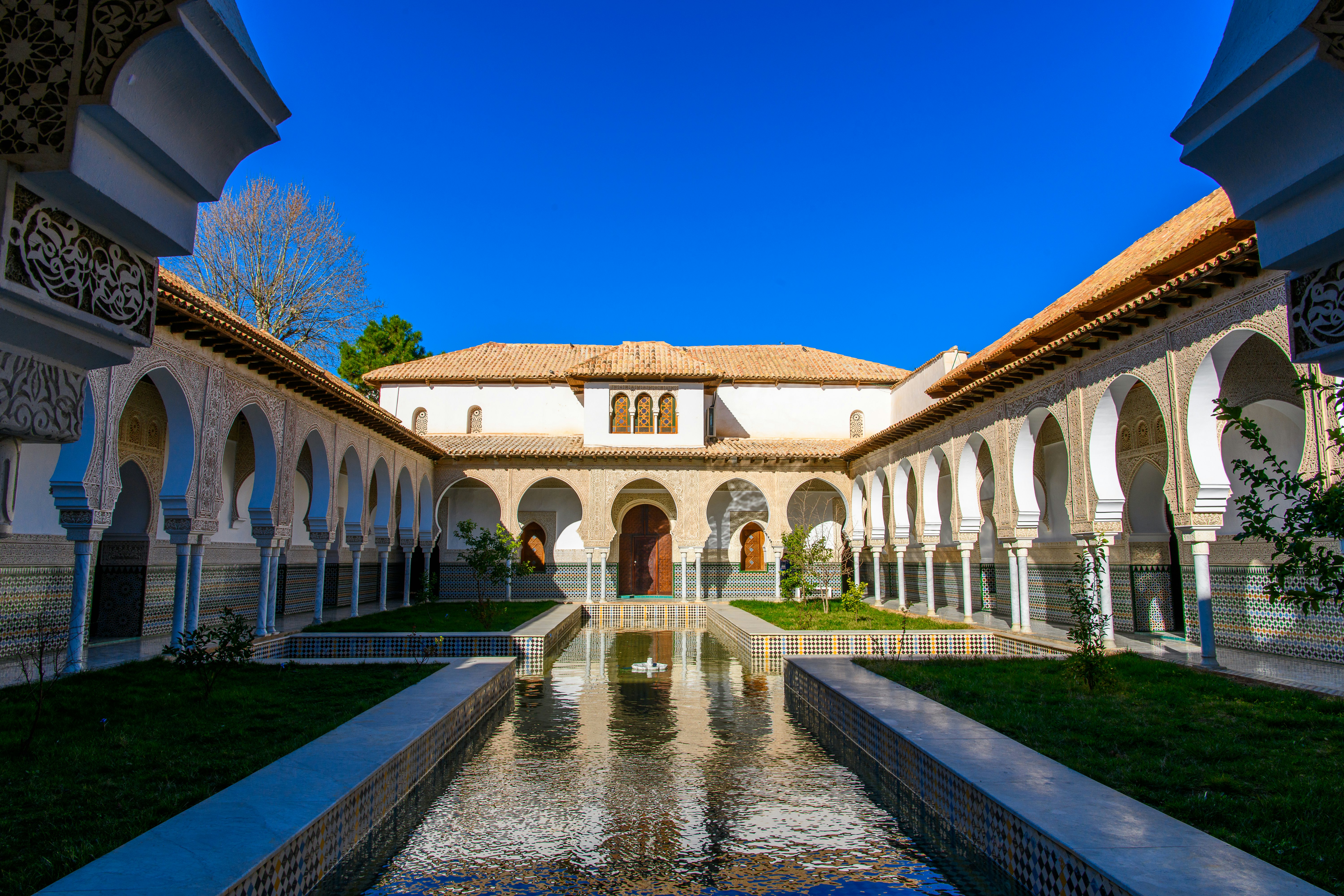 An Arab-style courtyard with a central water feature and tiled walls.