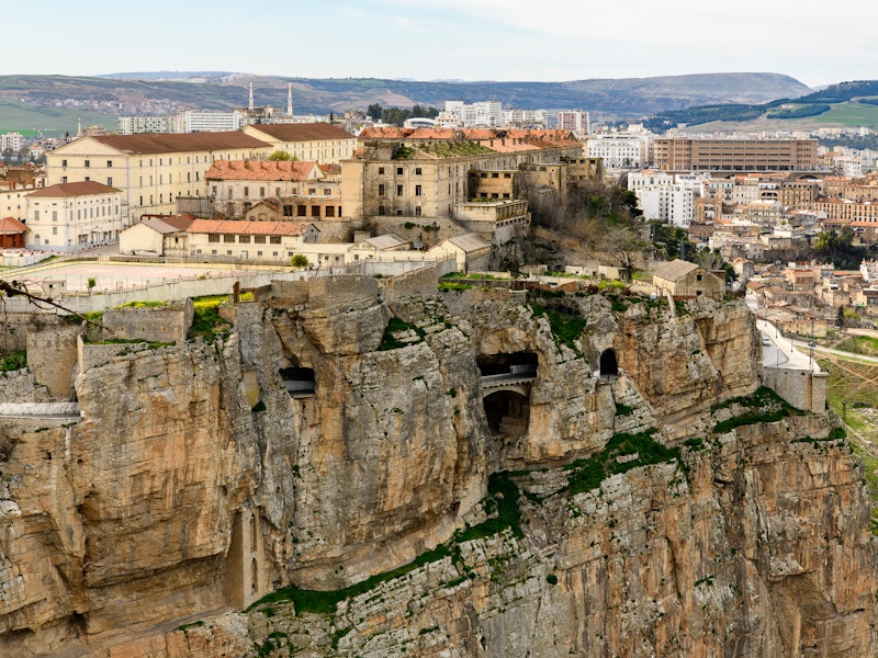 A town in Algeria built on top of a tall rock cliff.