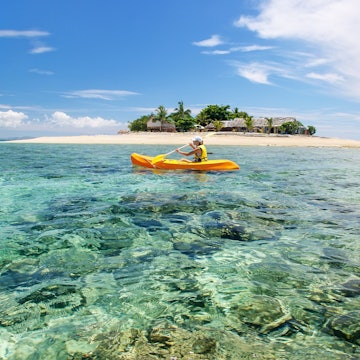 Young woman kayaking near South Sea Island, Mamanuca islands group, Fiji. This group consists of about 20 islands., License Type: media, Download Time: 2025-05-28T10:04:48.000Z, User: lonelyplanetmedia, Editorial: false, purchase_order: 65050 - Digital Destinations and Articles, job: Global Publishing WIP, client: Global Publishing WIP, other: Peterson Haggarty // SS Comp Ingestion