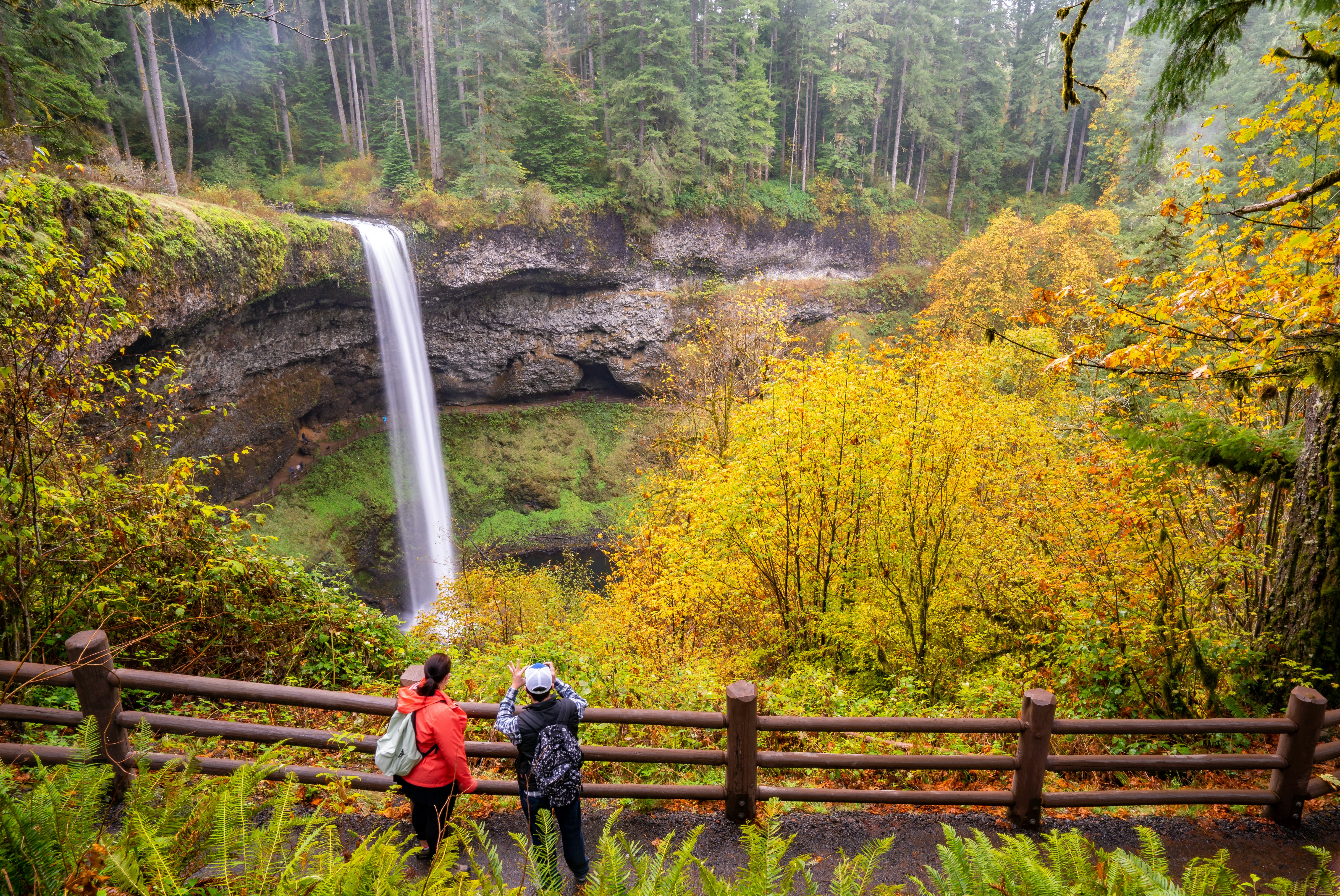 Two people taking photos of South Falls at Silver Falls State Park