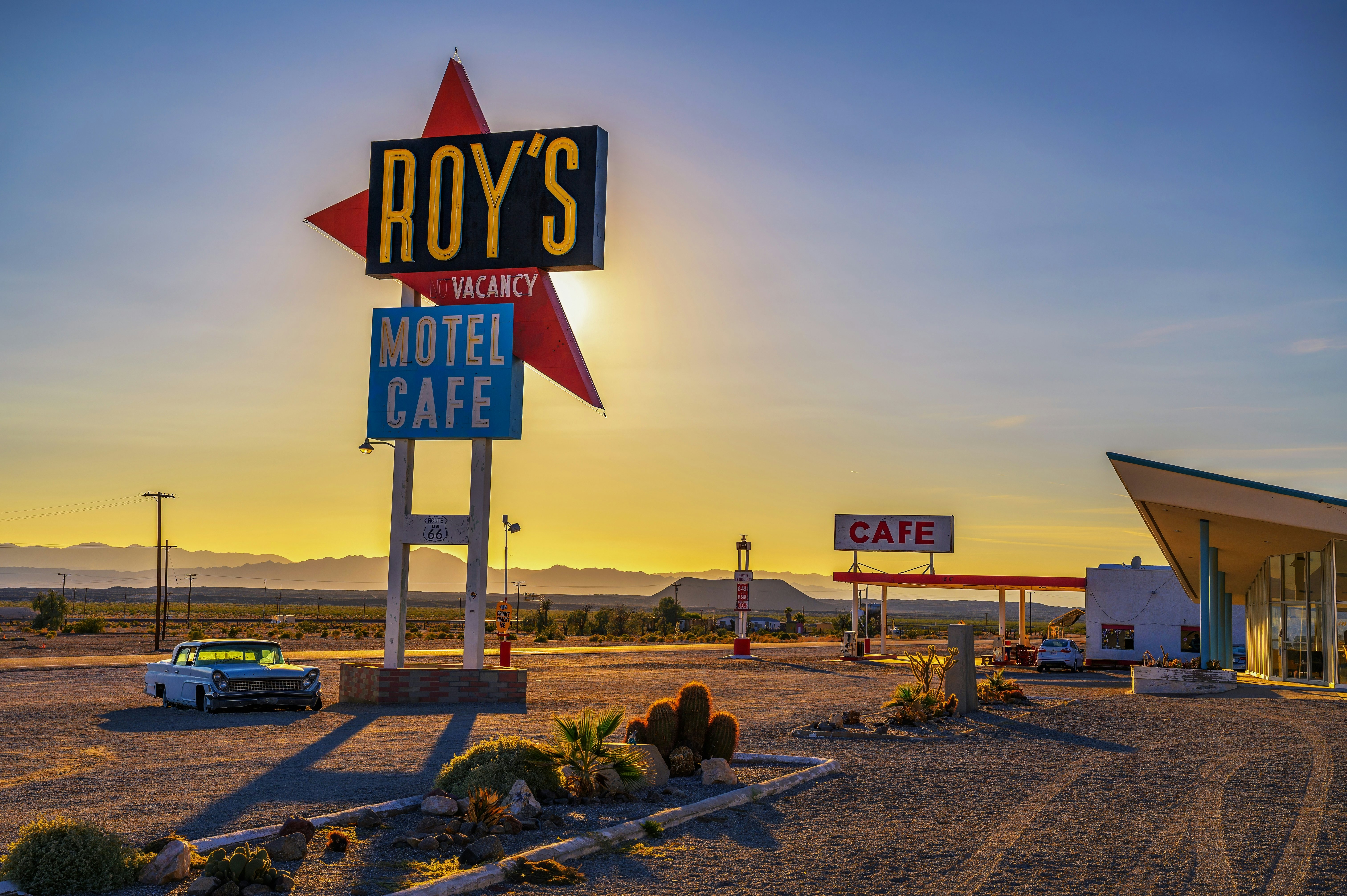 A sign with vintage design advertising a motel on a desert highway is pictured at sunset.