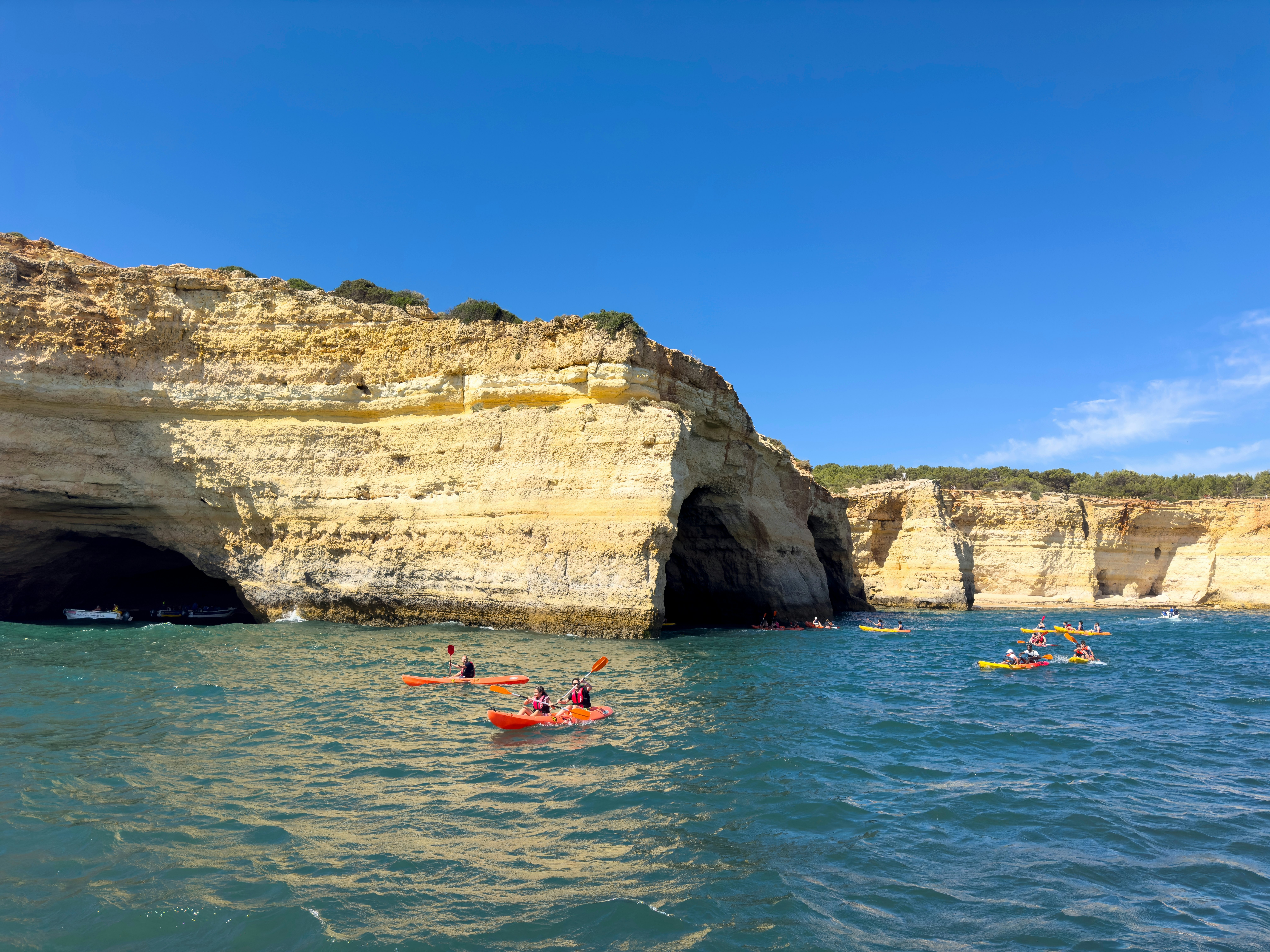 People kayaking on the Algarve coastline.