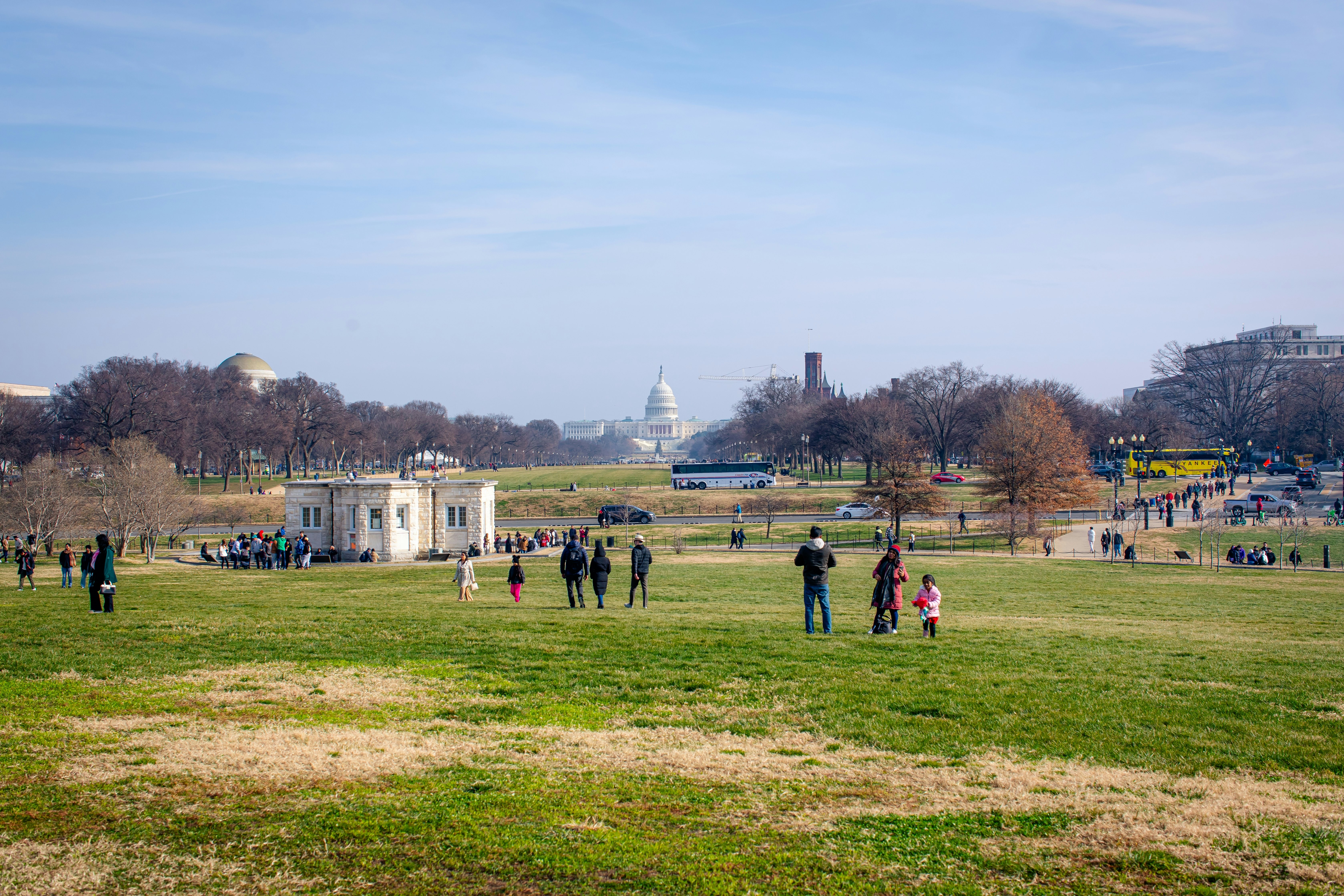 The National Mall, large grassy park area downtown Washington DC with some people walking and the building of The Capitol in the background