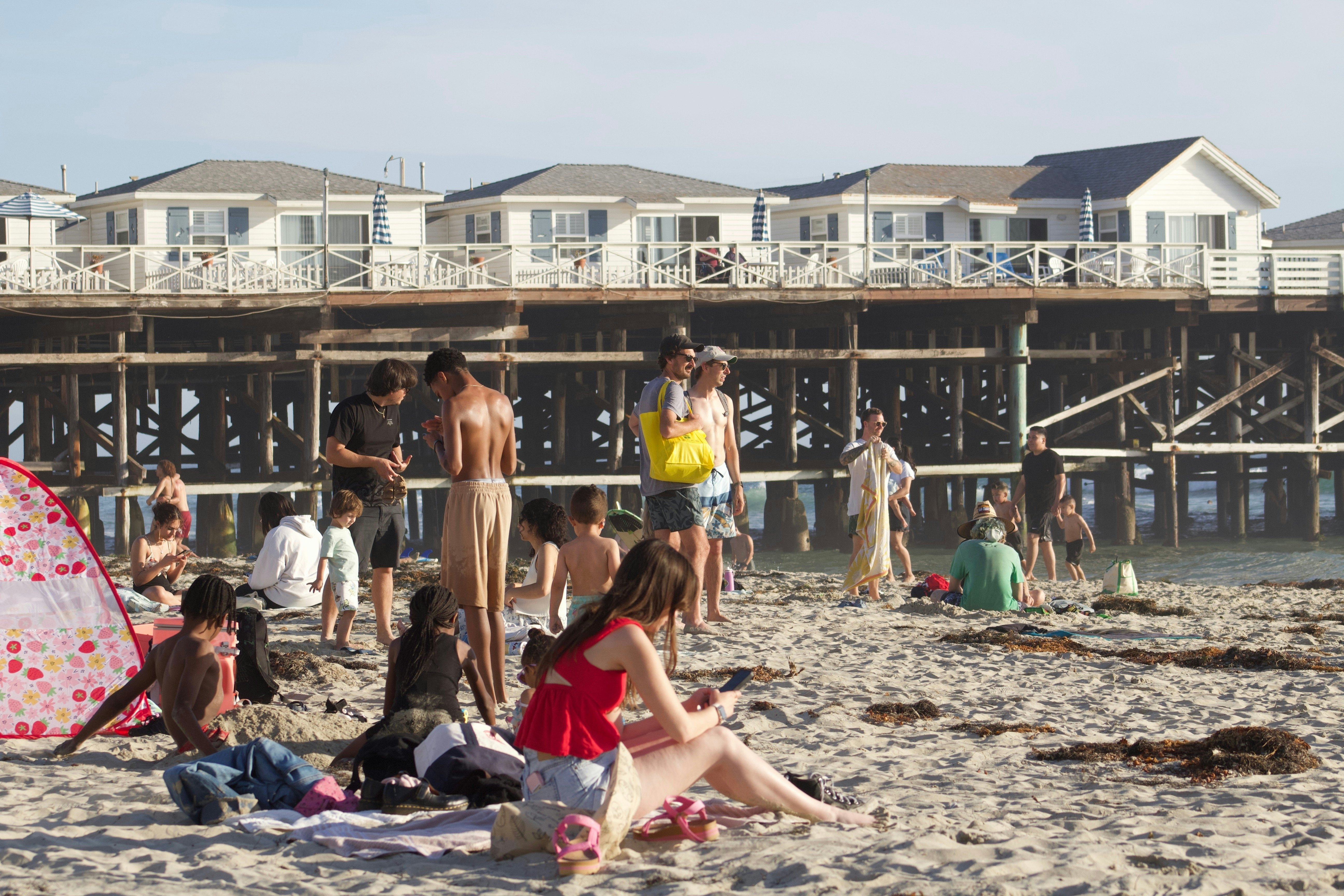 Beachgoers line a busy beach in San Diego