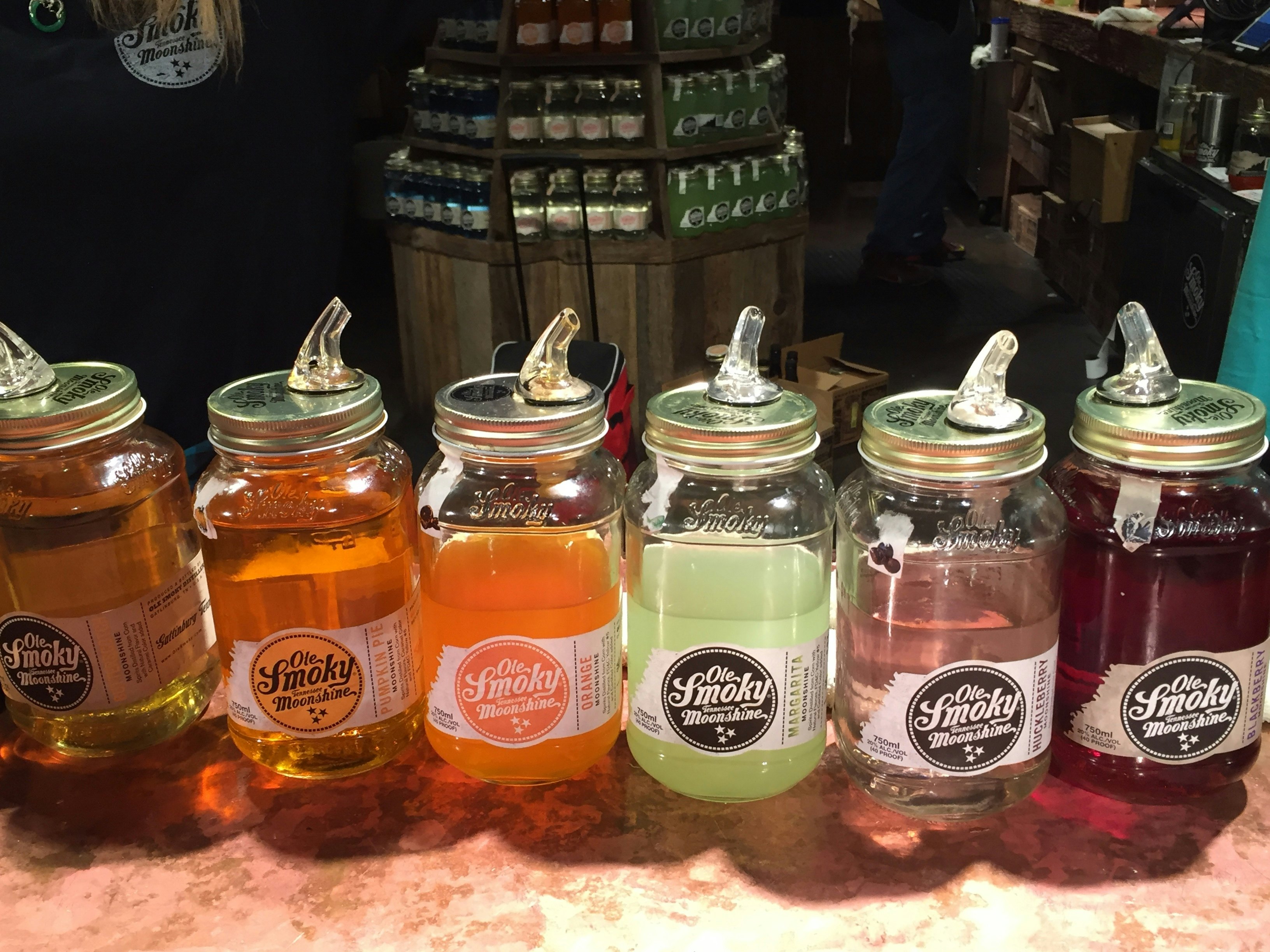 Jars containing colored liquors to taste are displayed on the counter of a distillery.