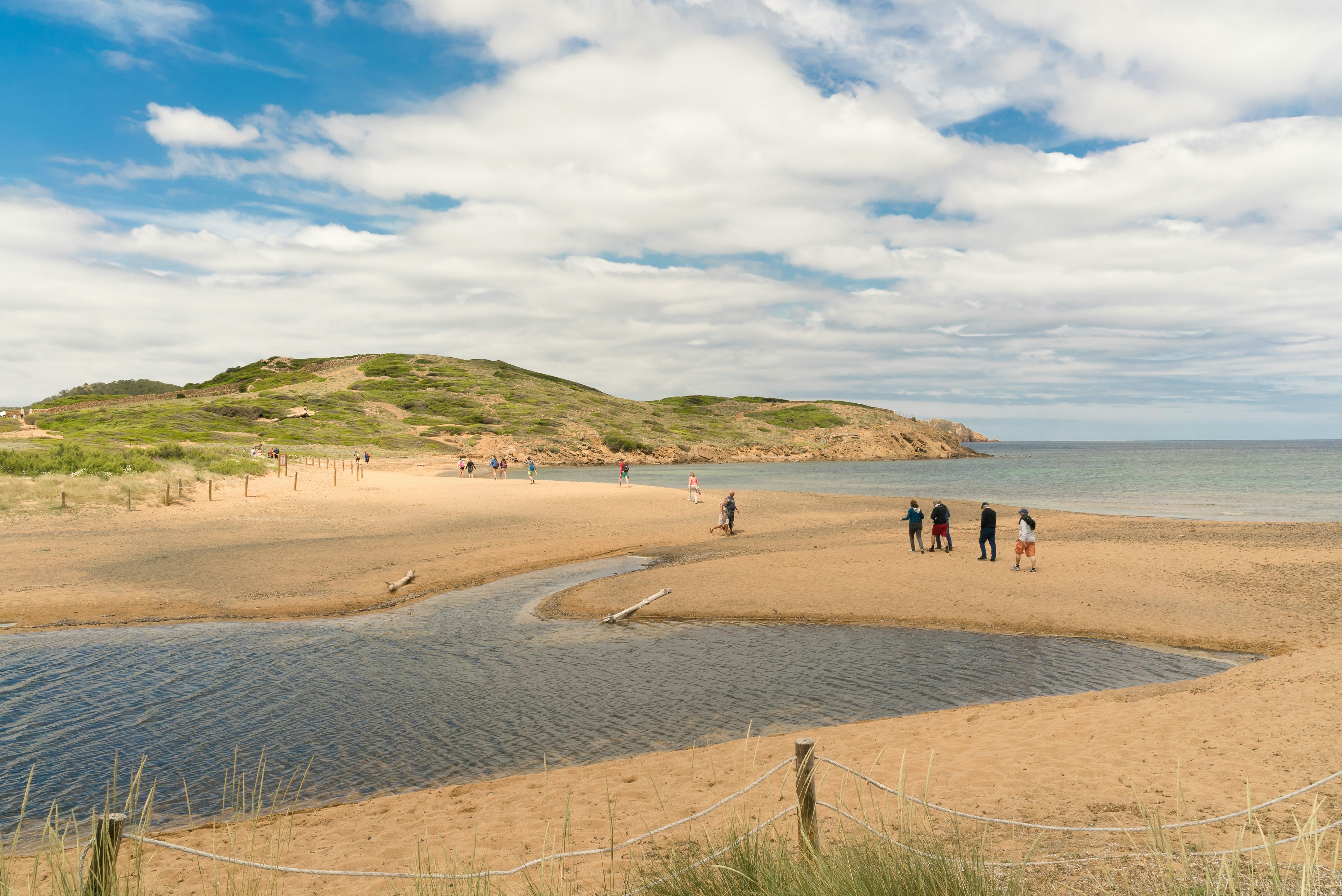 Tourist are walking through the Camí de Cavalls (Horse Road) of Menorca. It is a historic heritage and declared of cultural interest in the Balearic Islands. Spain