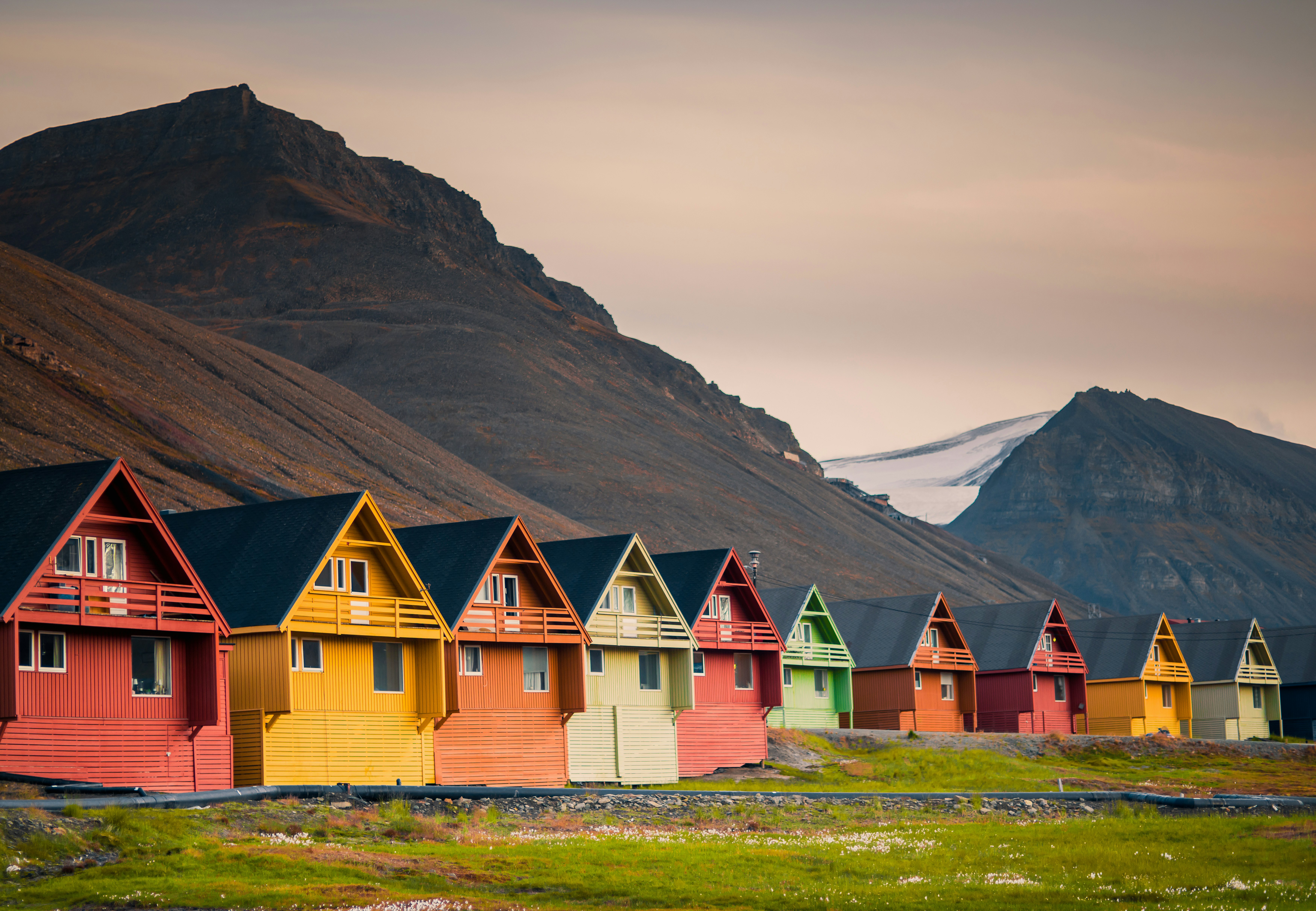 A row of colorful homes in Longyearben with mountains behind them