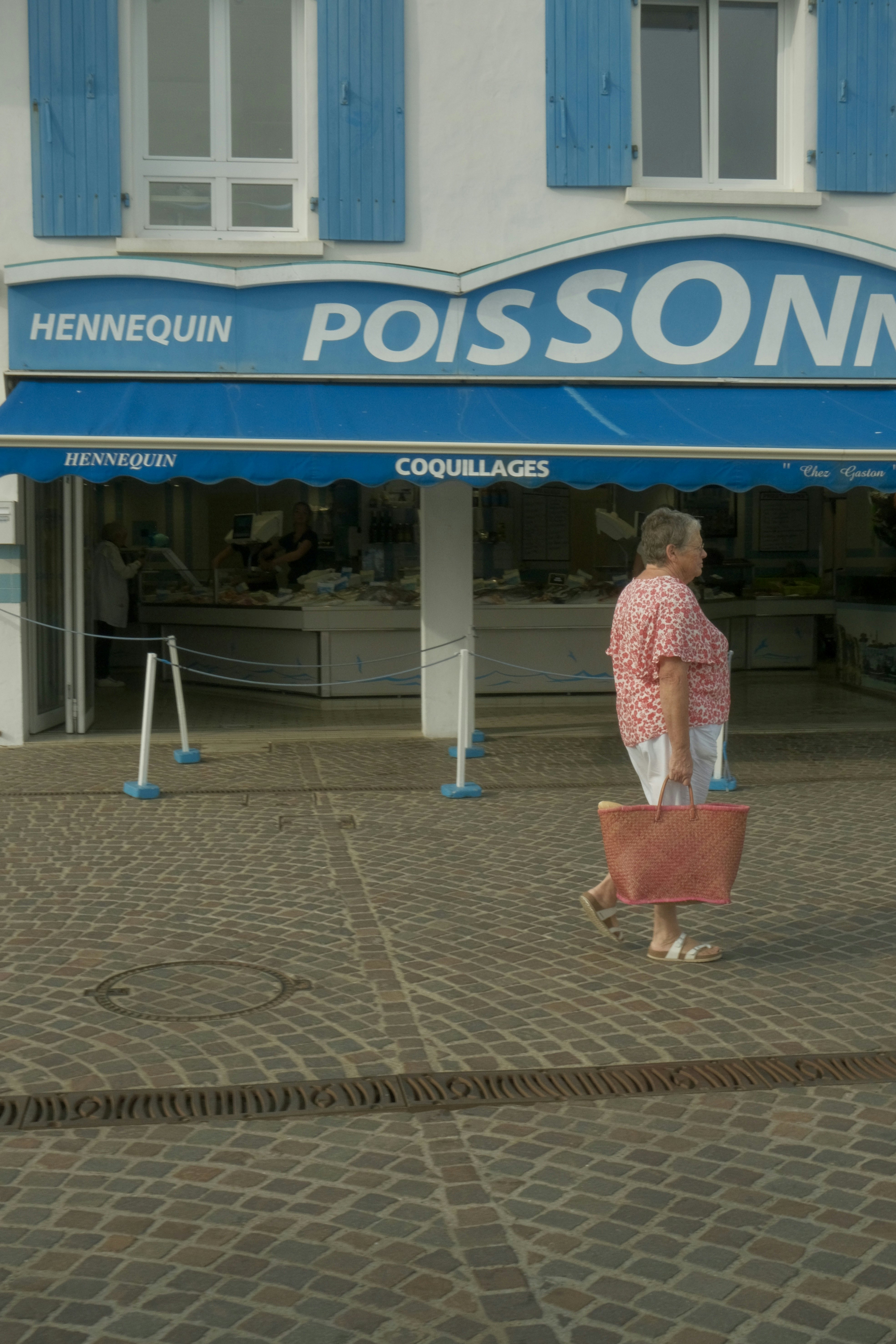 A woman walks by a fish shop on Île d'Yeu in the Vendée region of France