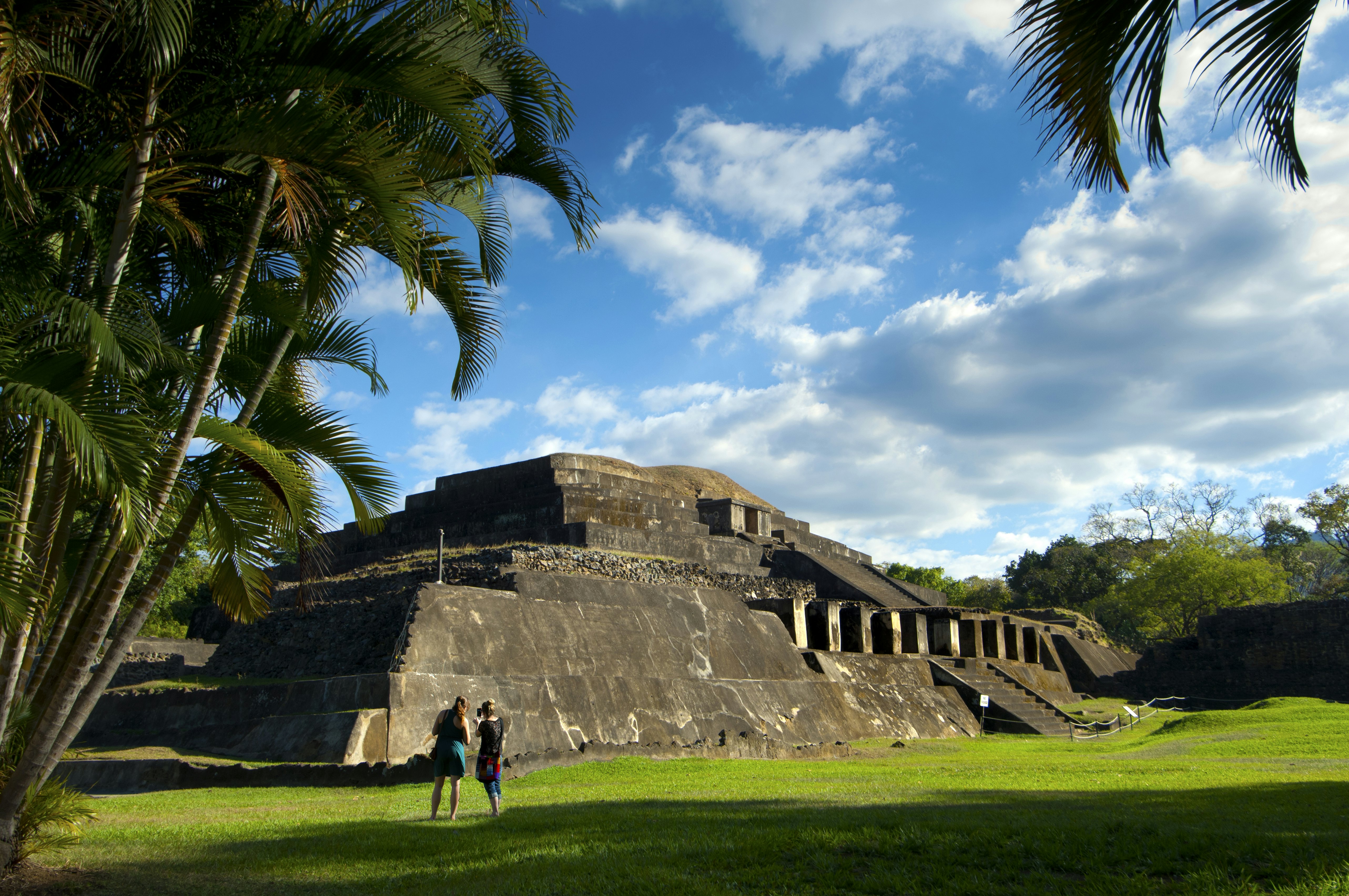 Visitors photograph the ruins of a stepped pyramid