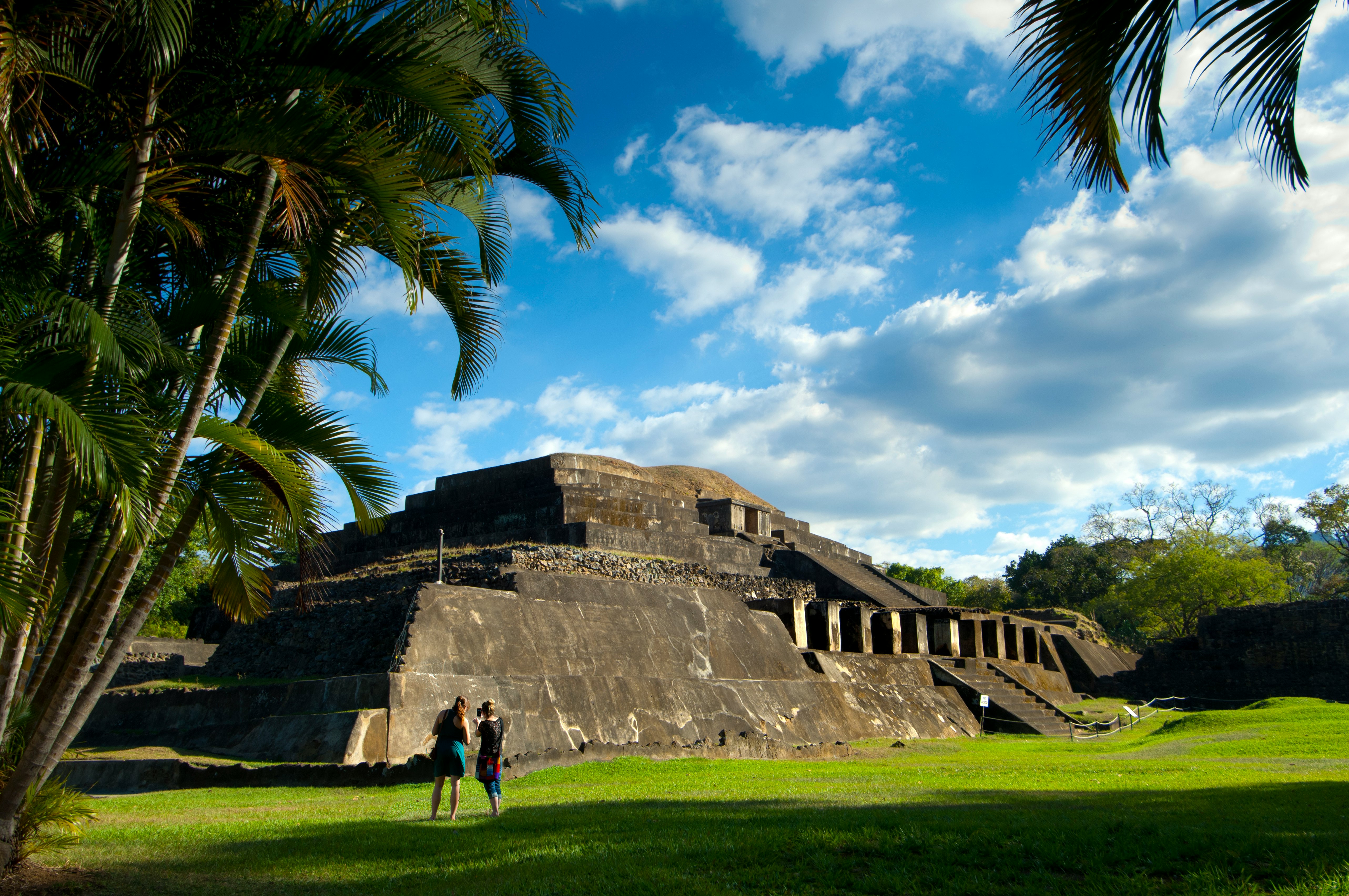Visitors photograph the ruins of a stepped pyramid