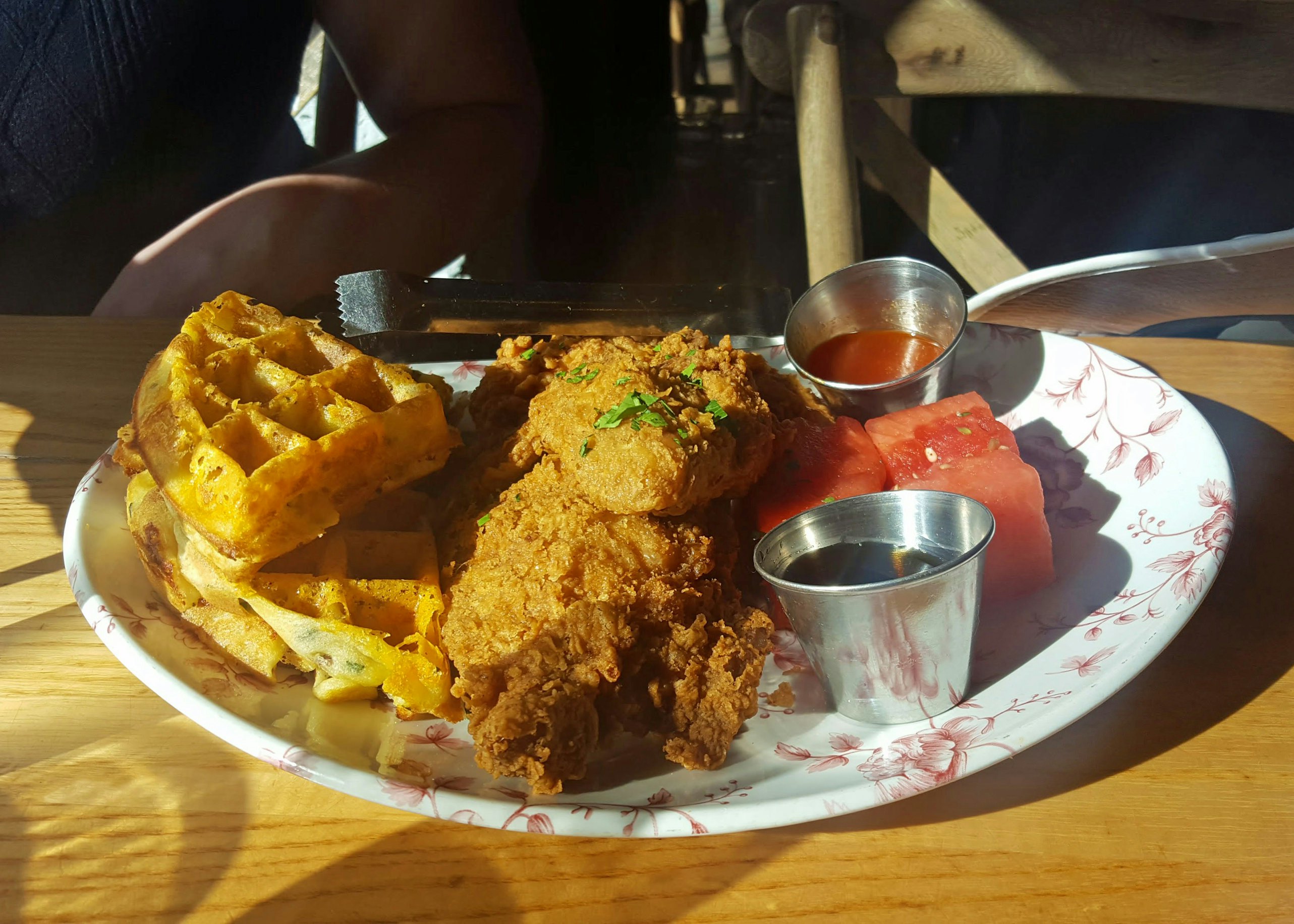 Sunday morning brunch of fried chicken, waffles, and marinated watermelon with bourbon maple syrup and hot sauce at Yardbird Southern Table and Bar in Miami Beach, Florida.