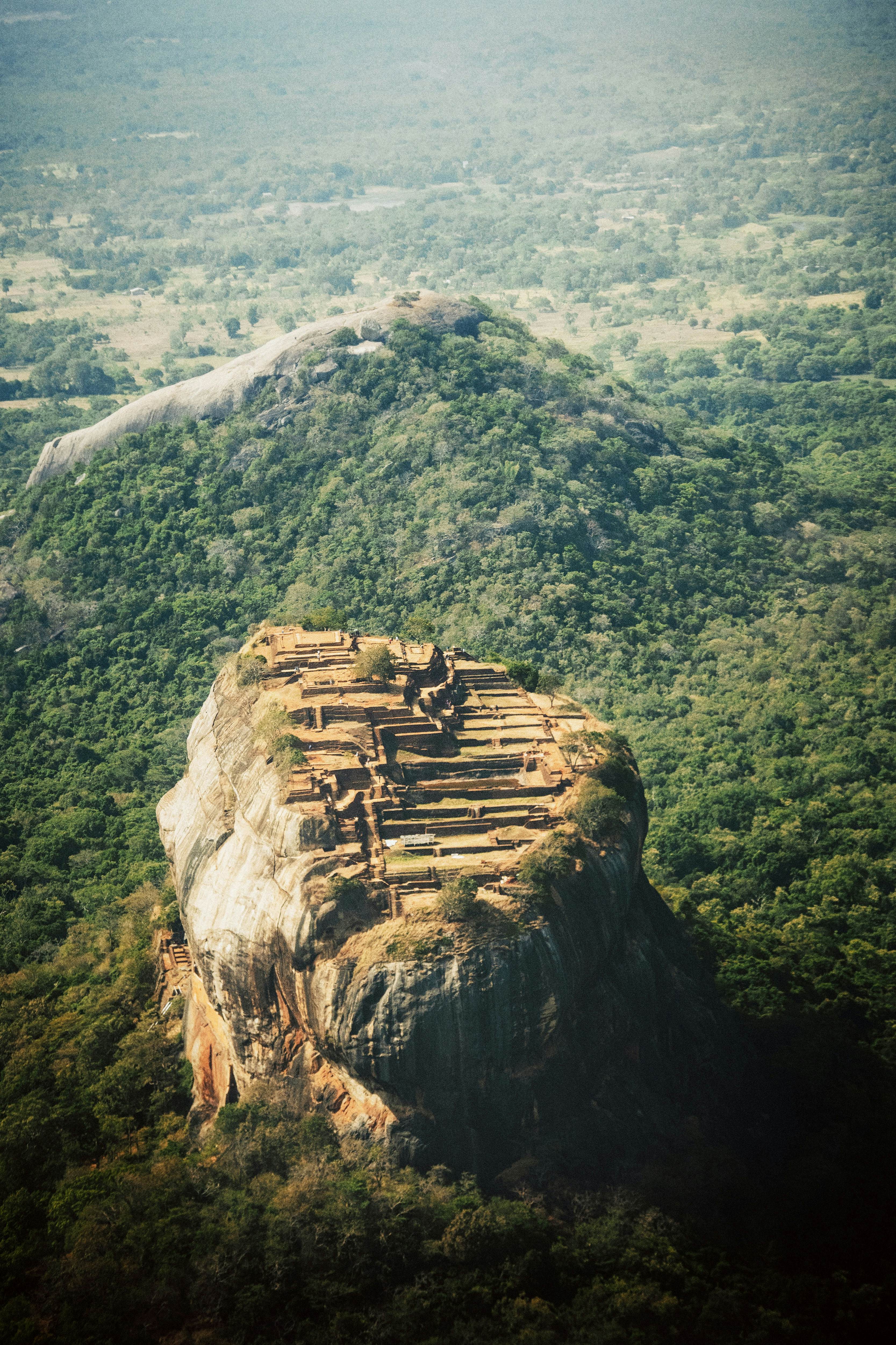 An aerial view of a rock fortress above lush vegetation in Sri Lanka.