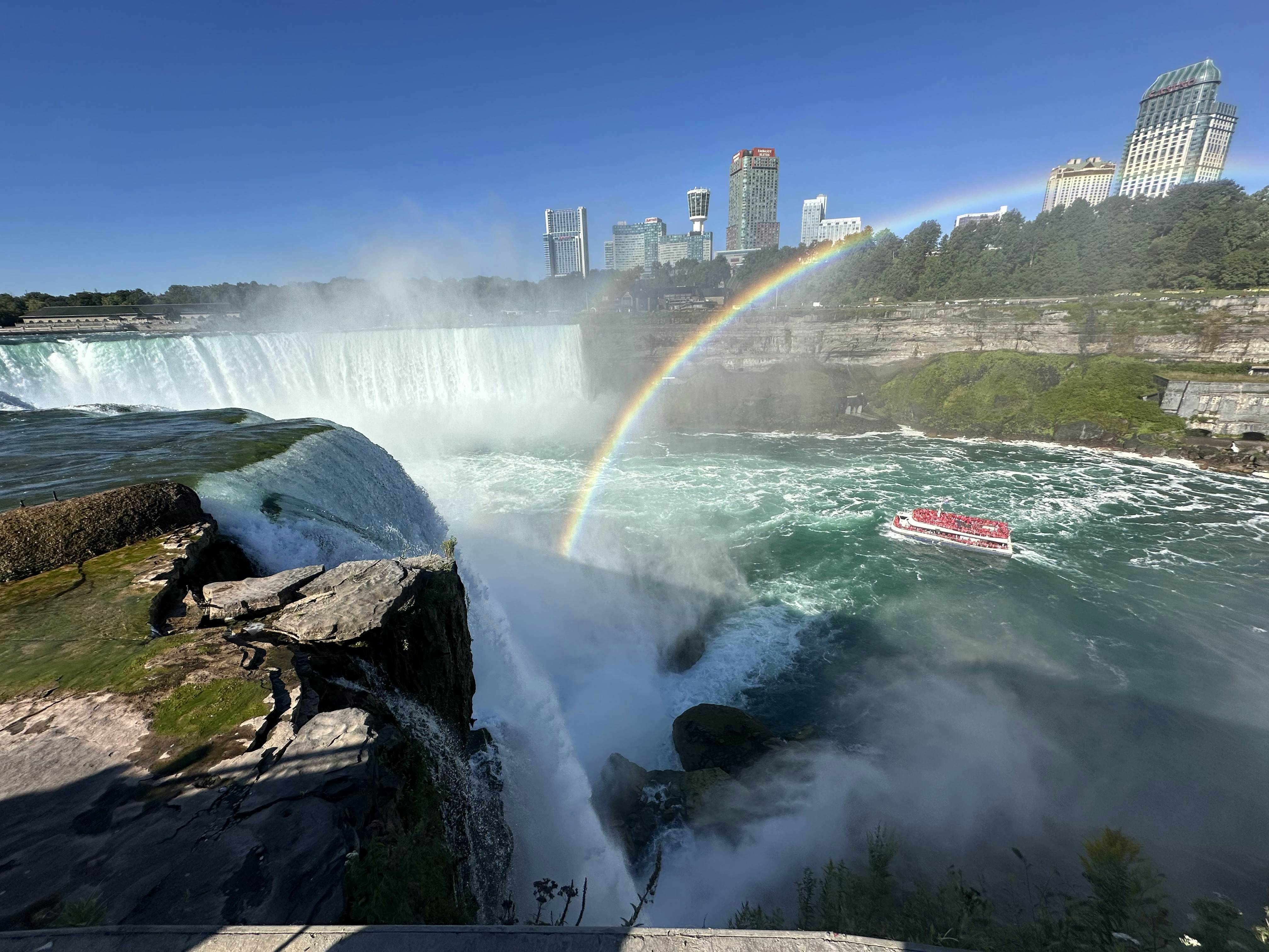 The falls creating a heavy mist with green blue water below. 