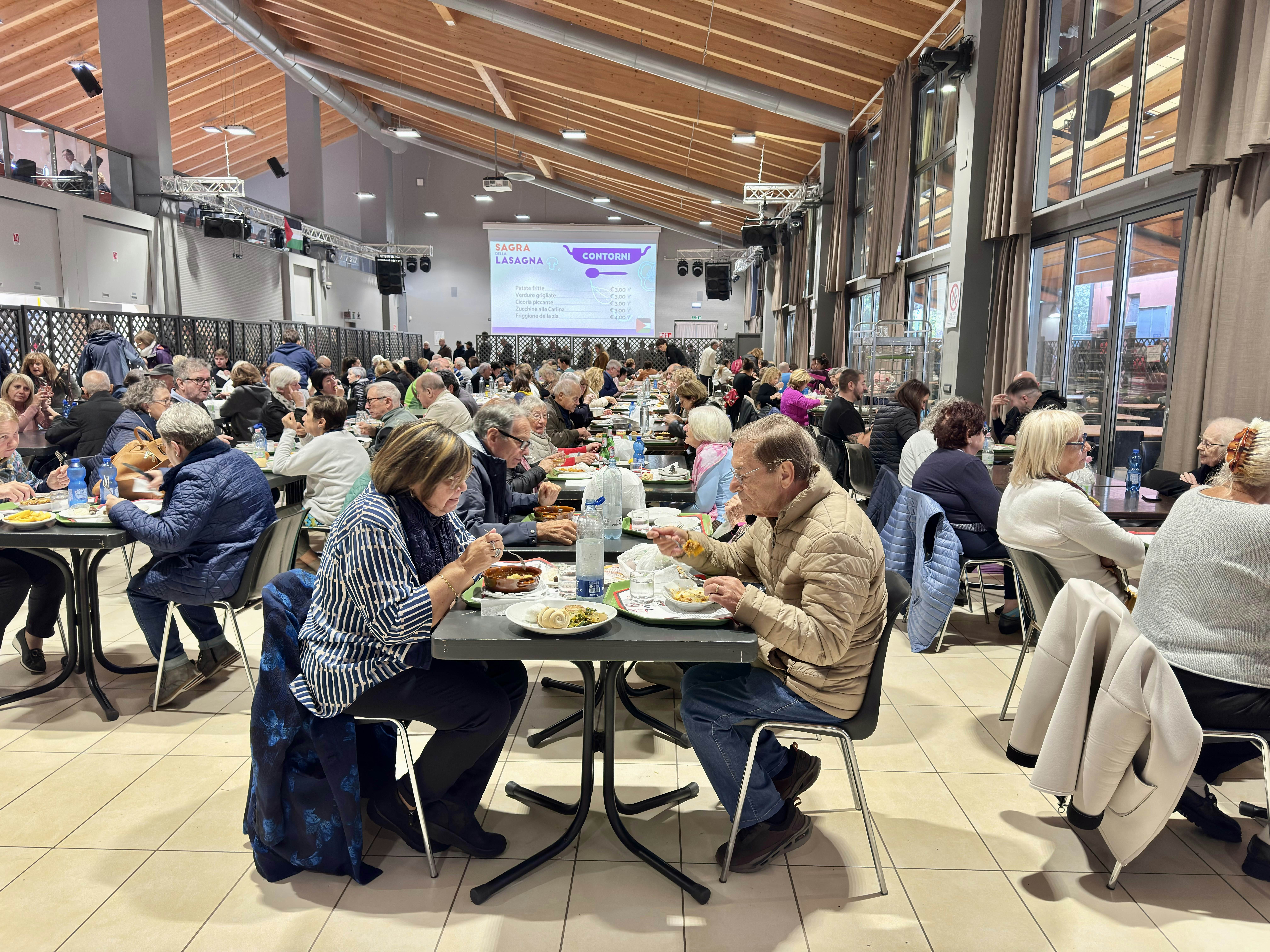 People on long folding tables eat