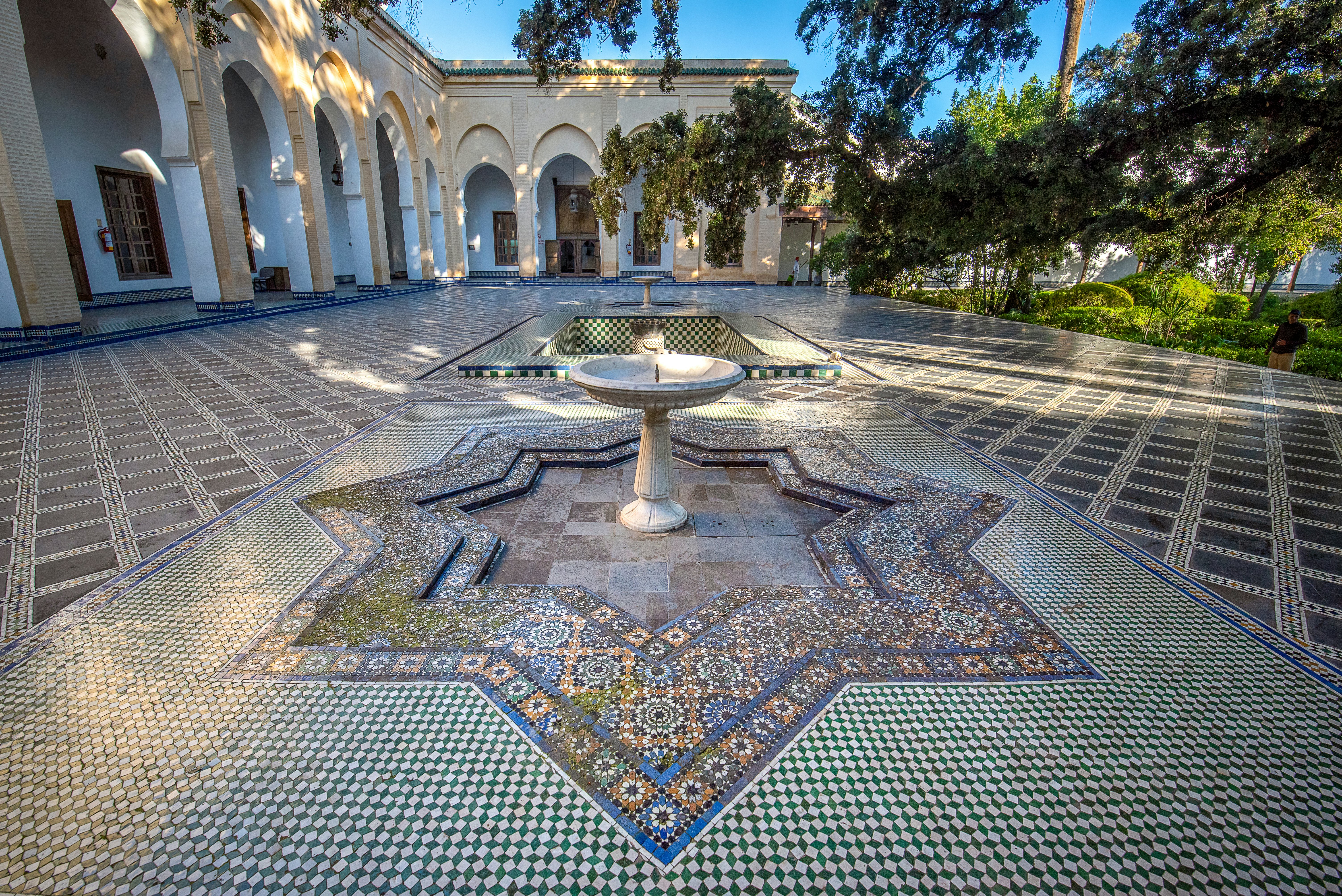 An intricately tiled courtyard with a central fountain.