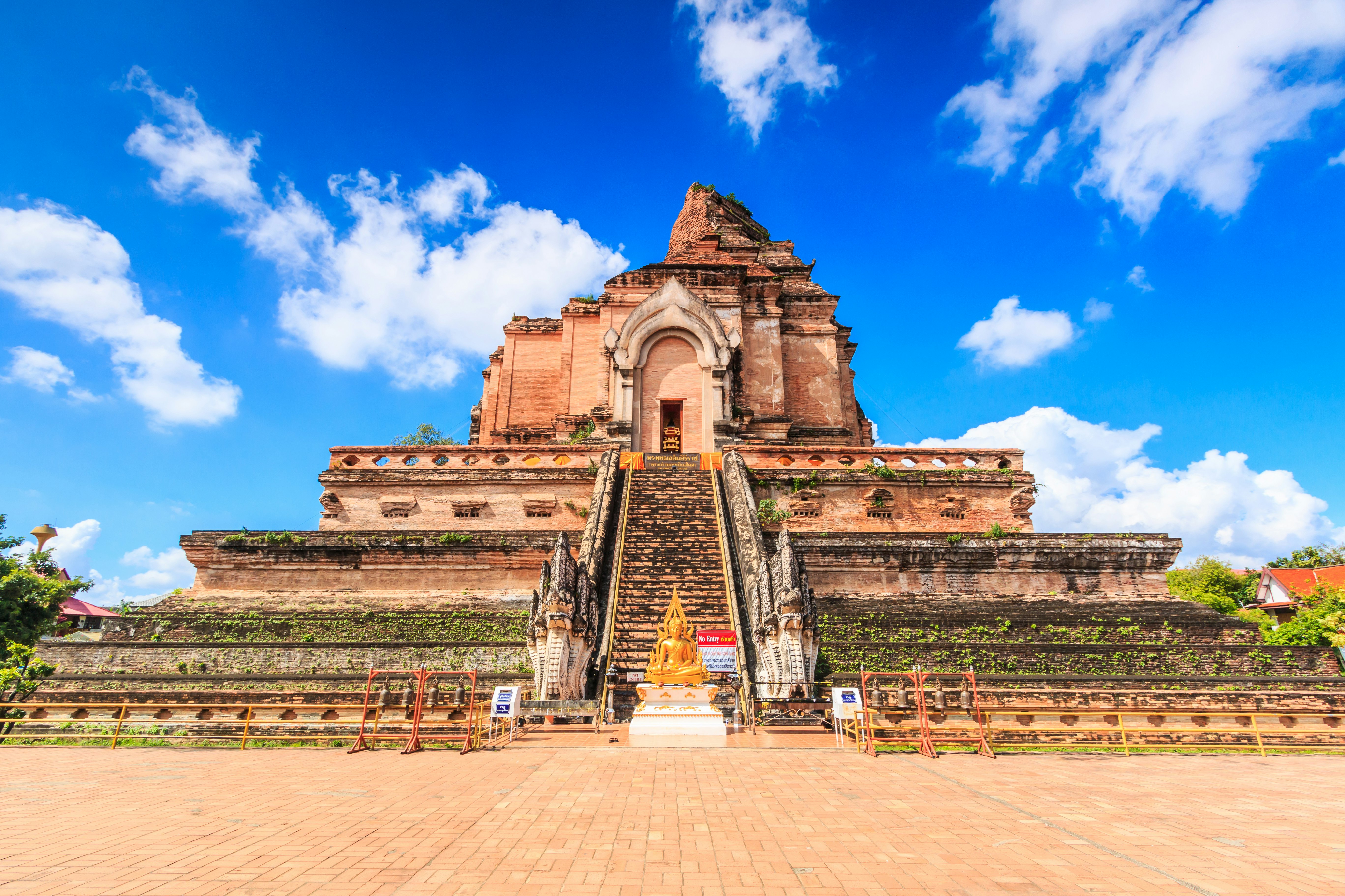An ancient pagoda with Buddha statue in front