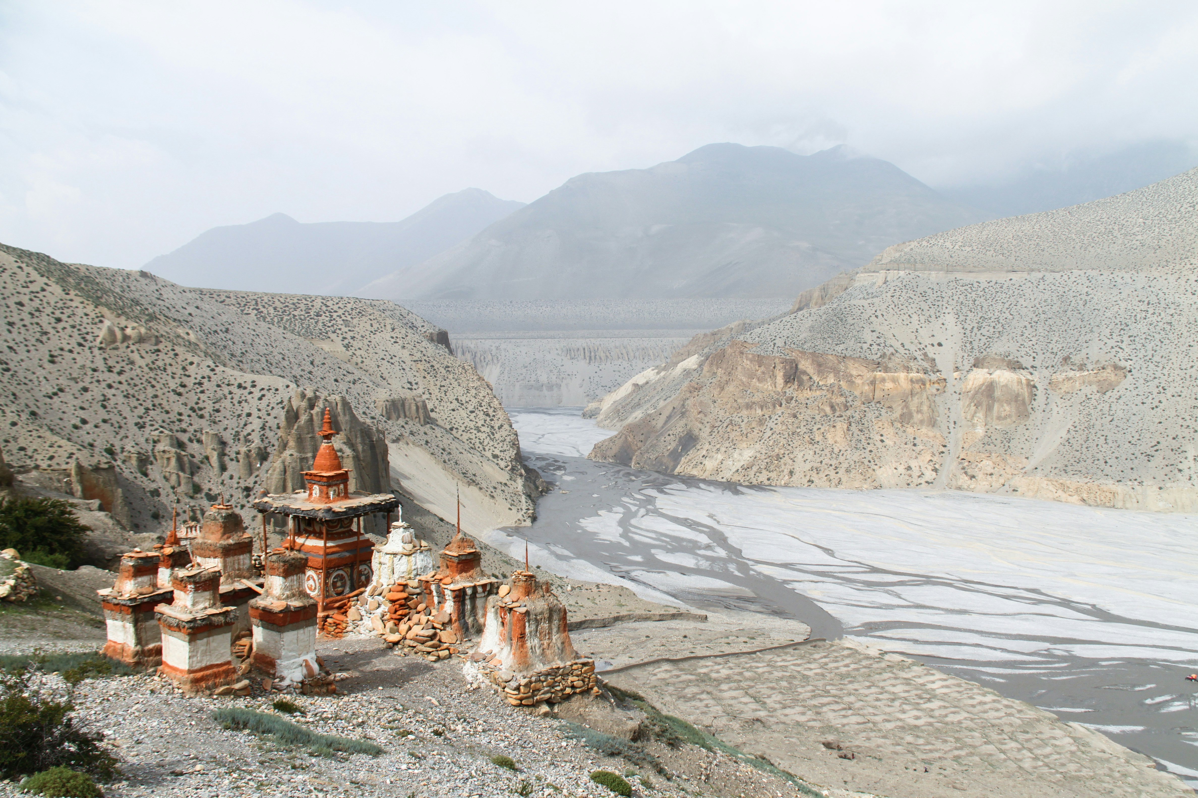 Buddhist stupas on a hill at the top of a river valley.