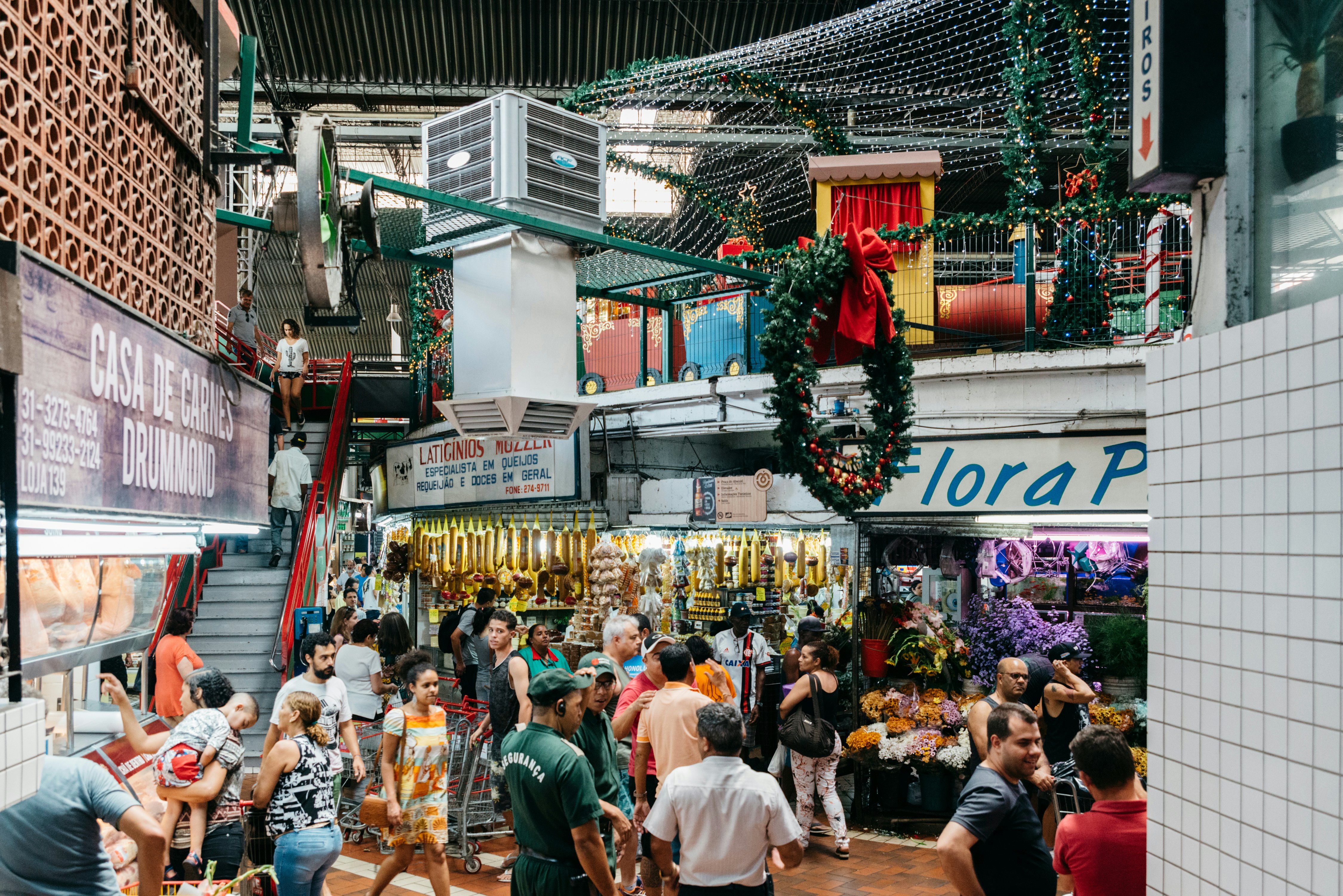People strolling in a lively indoor market featuring food, crafts and souvenir vendors, and places to eat