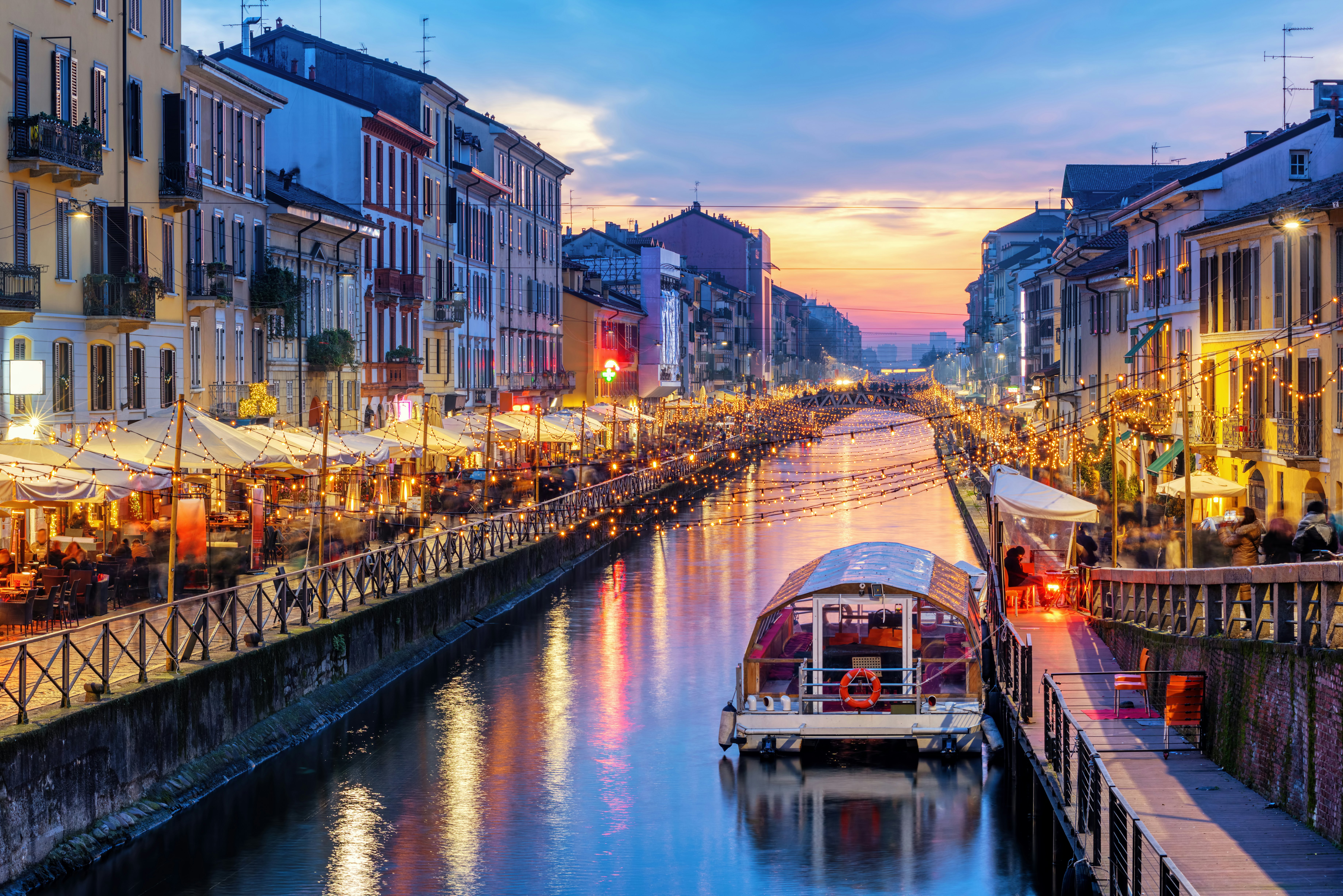 A cafe- and restaurant-lined canal lit up at twilight.