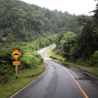 Curvy road through the jungle of northern Thailand - Caution bumps sign, License Type: media, Download Time: 2025-10-31T19:13:59.000Z, User: bhealy950, Editorial: false, purchase_order: 65050 - Digital Destinations and Articles, job: Lonely Planet Online Editorial, client: Best road trips in Thailand, other: Brian Healy