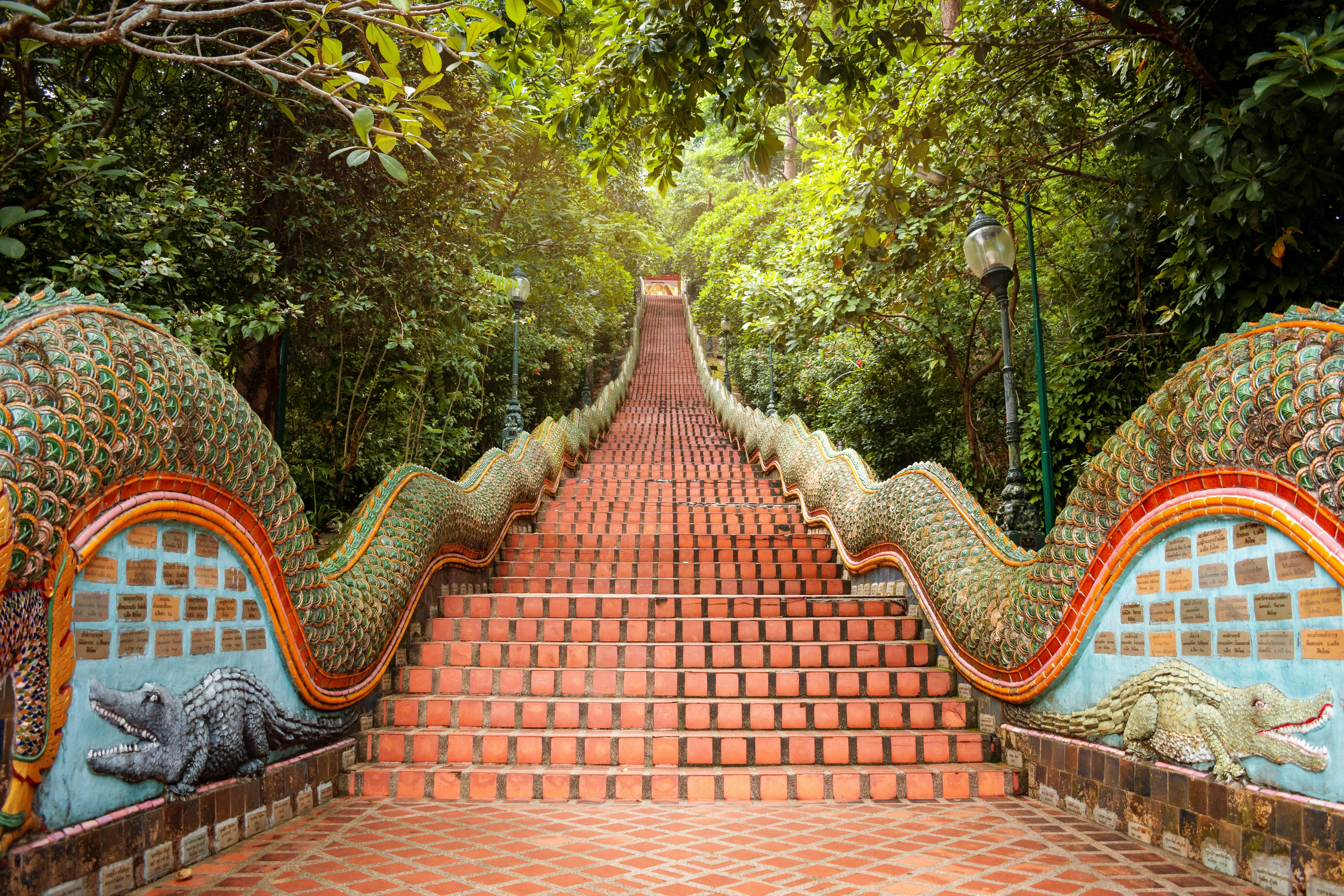 The orange staircase of Wat Phra That Doi Suthep Temple, with dragons and other colorful decor on the sides