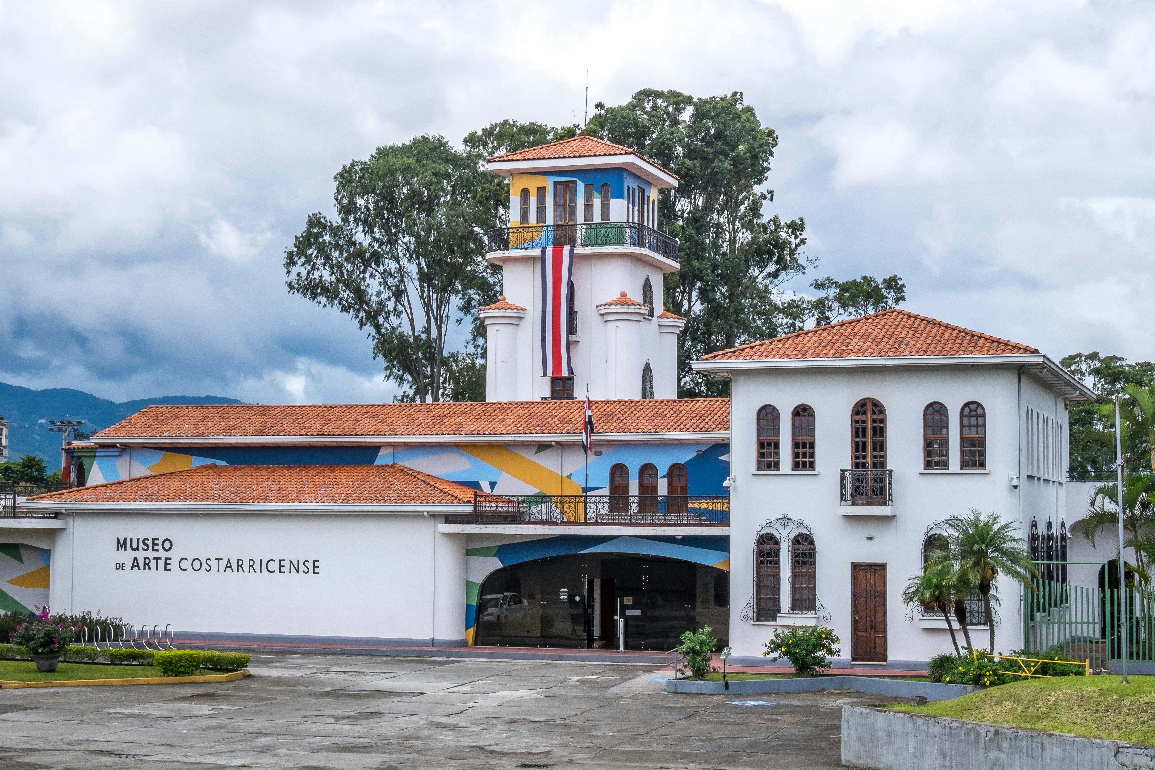 A white building with a partially painted facade. Letters spell out "Museo de arte costarricense"