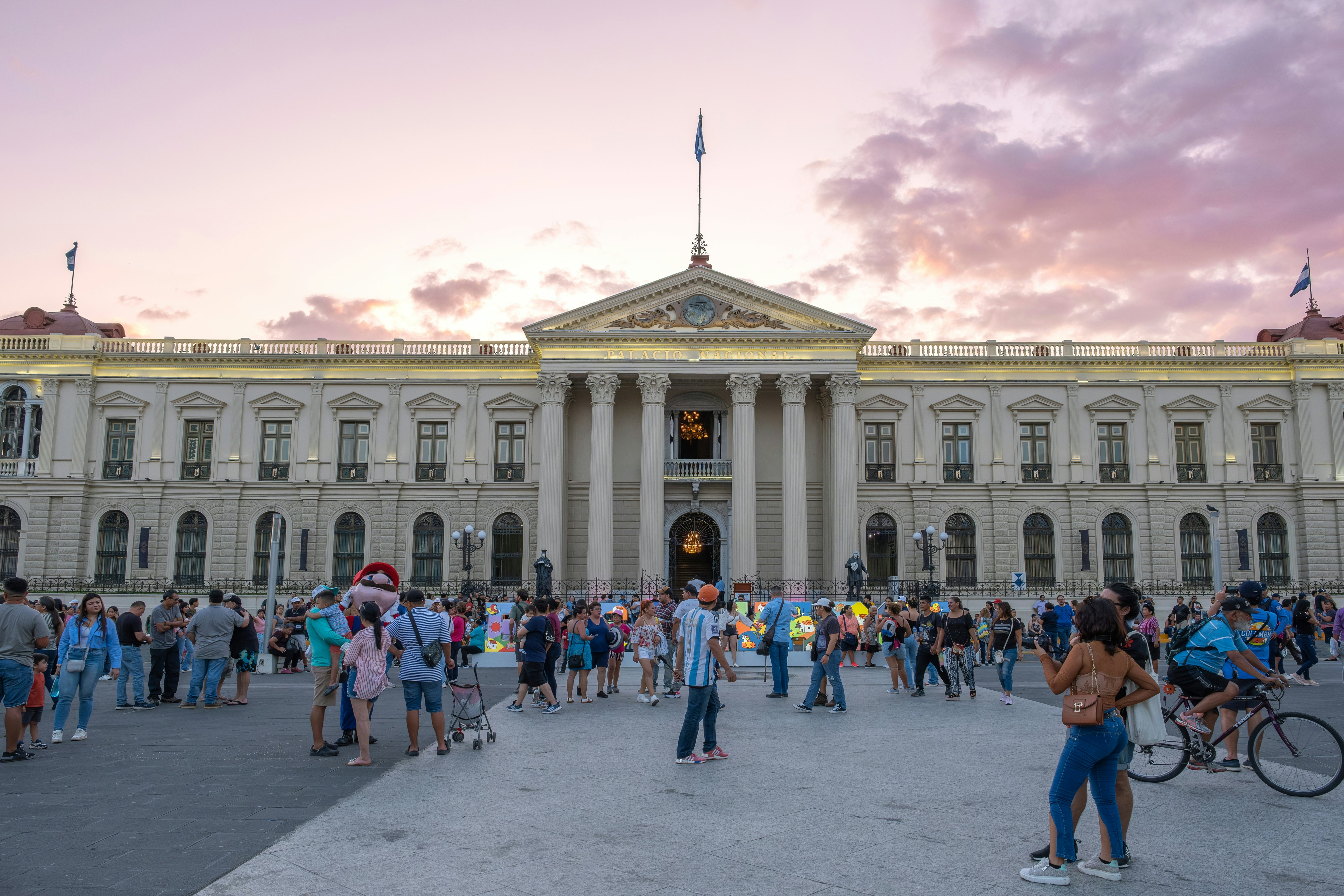 People walking in front of the Palacio Nacionale in San Salvador, El Salvador.