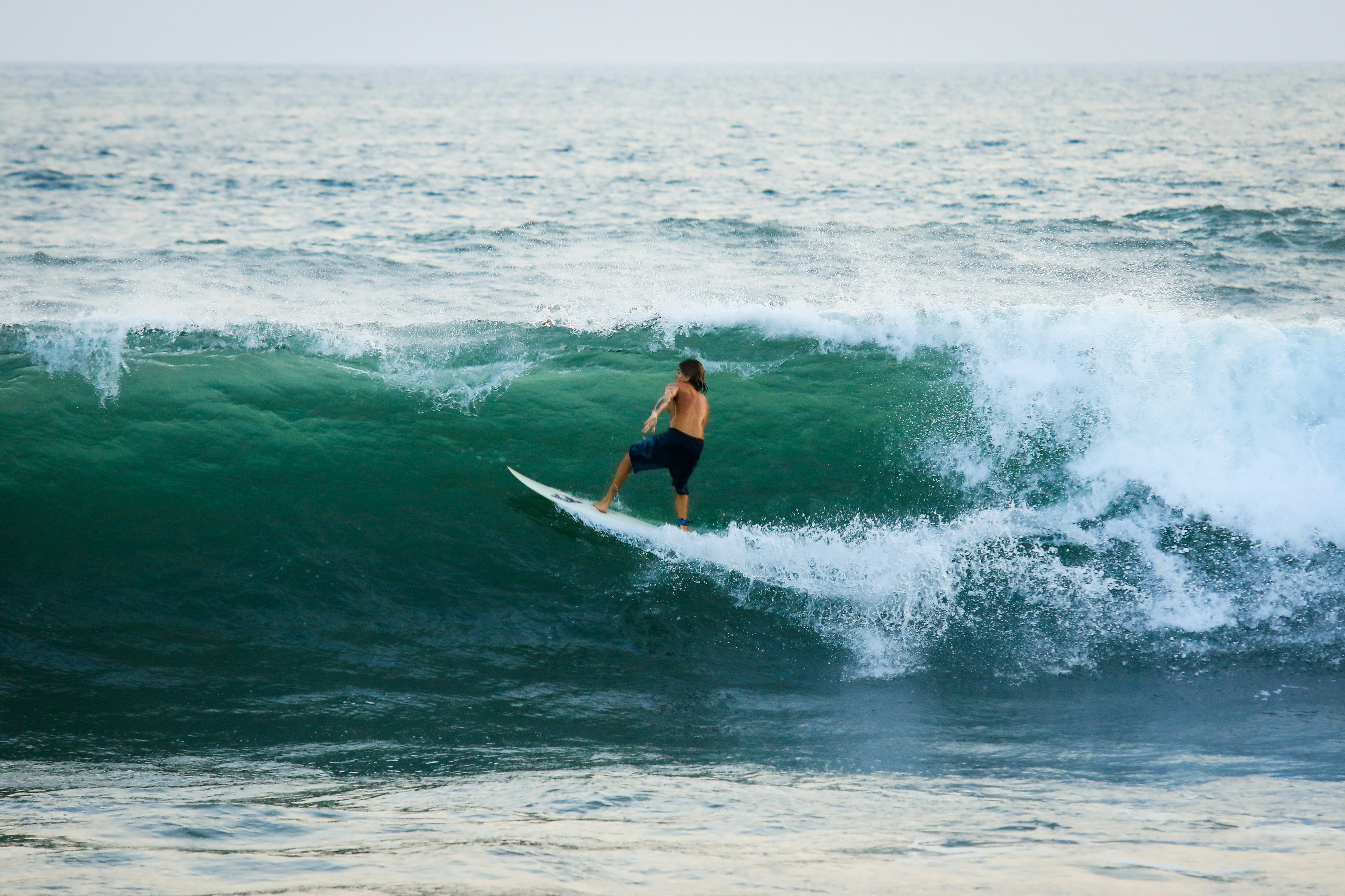 A surfer catching a wave at El Tunco, El Salvador.