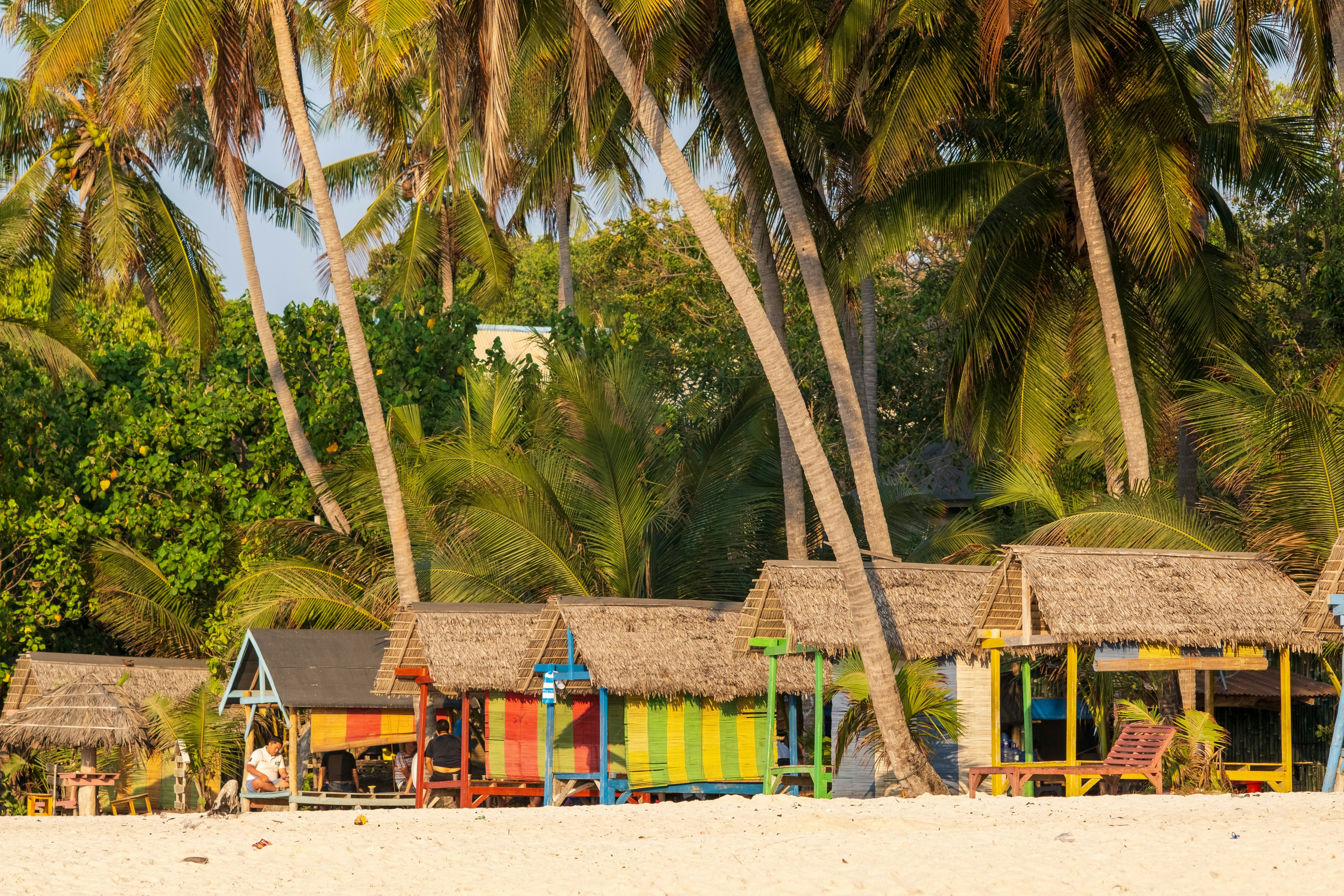 Huts on the beach under palm trees at Bira on Sulawesi, Indonesia.