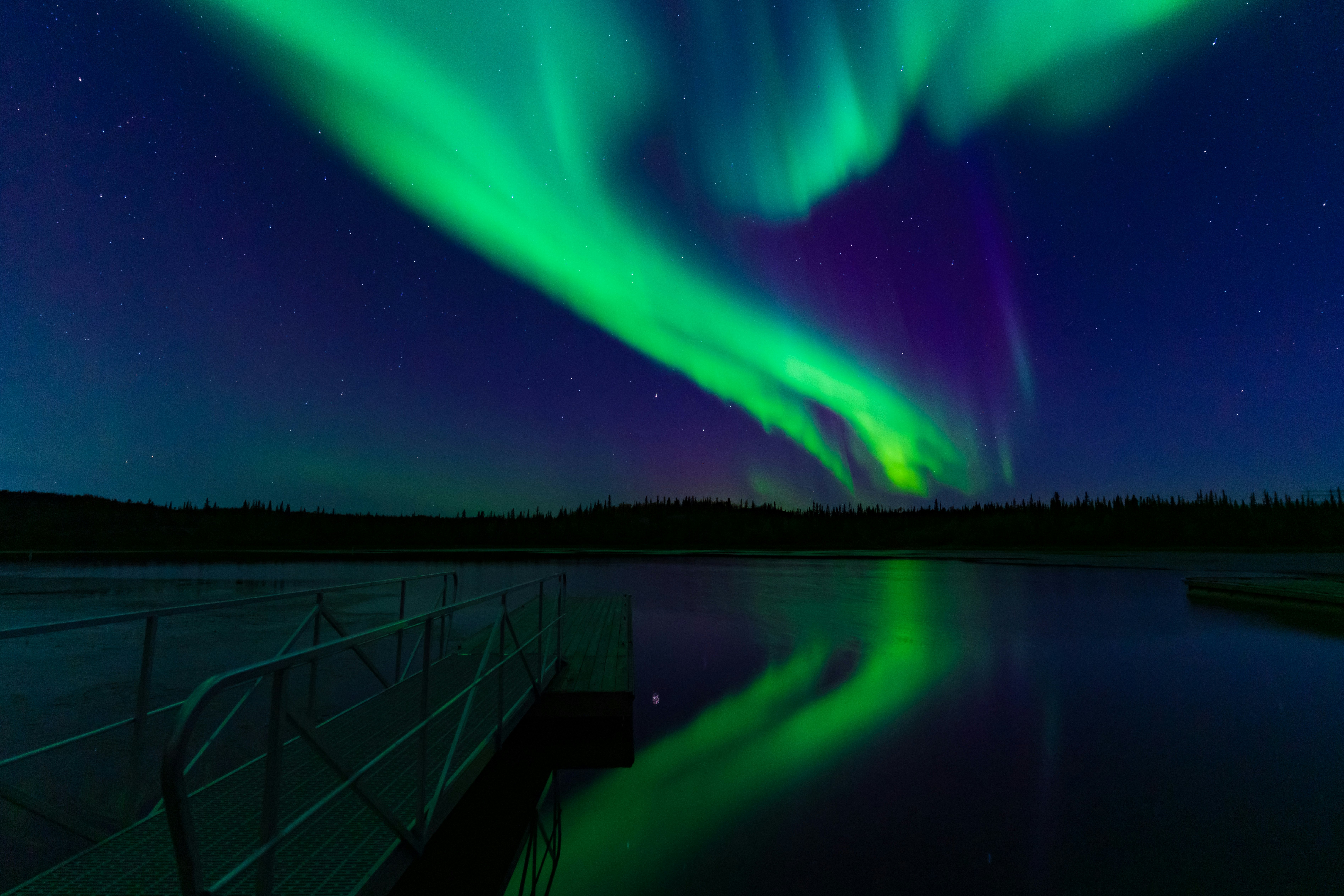 The northern lights shining above a lake in Canada.