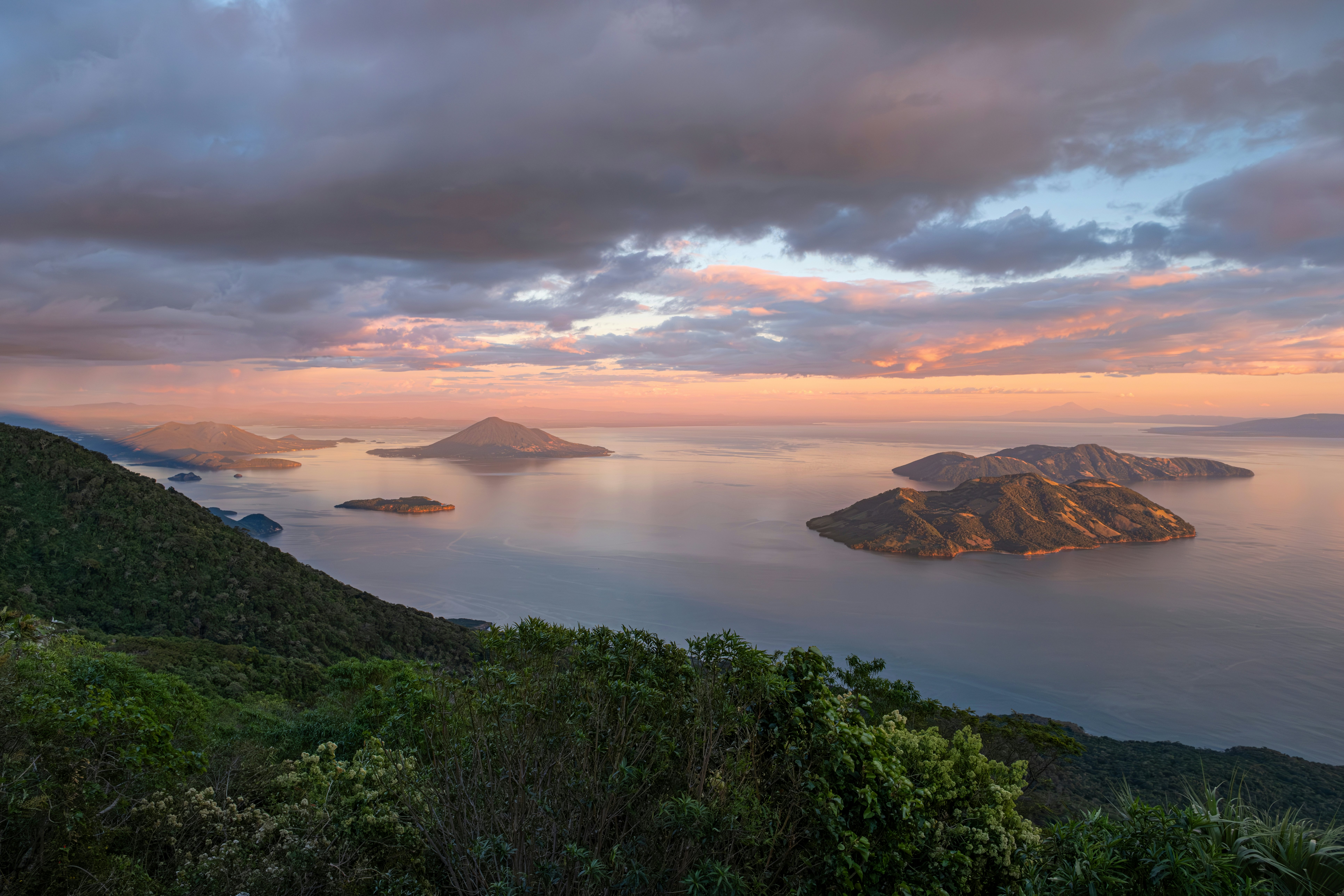 A pastel-colored sunset over several islands
