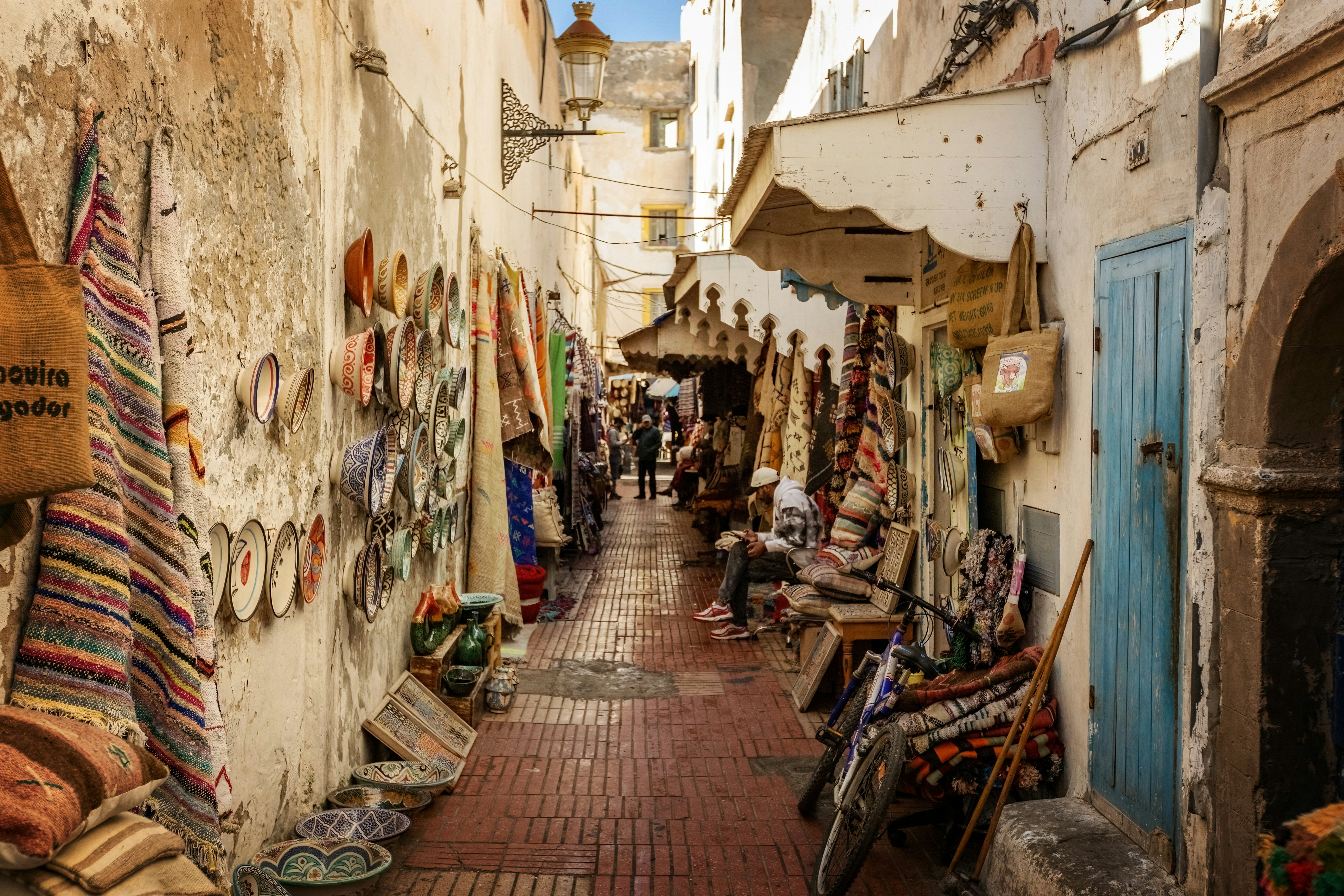 An alley in old city is filled with blankets, baskets and other handicrafts on sale from vendors.