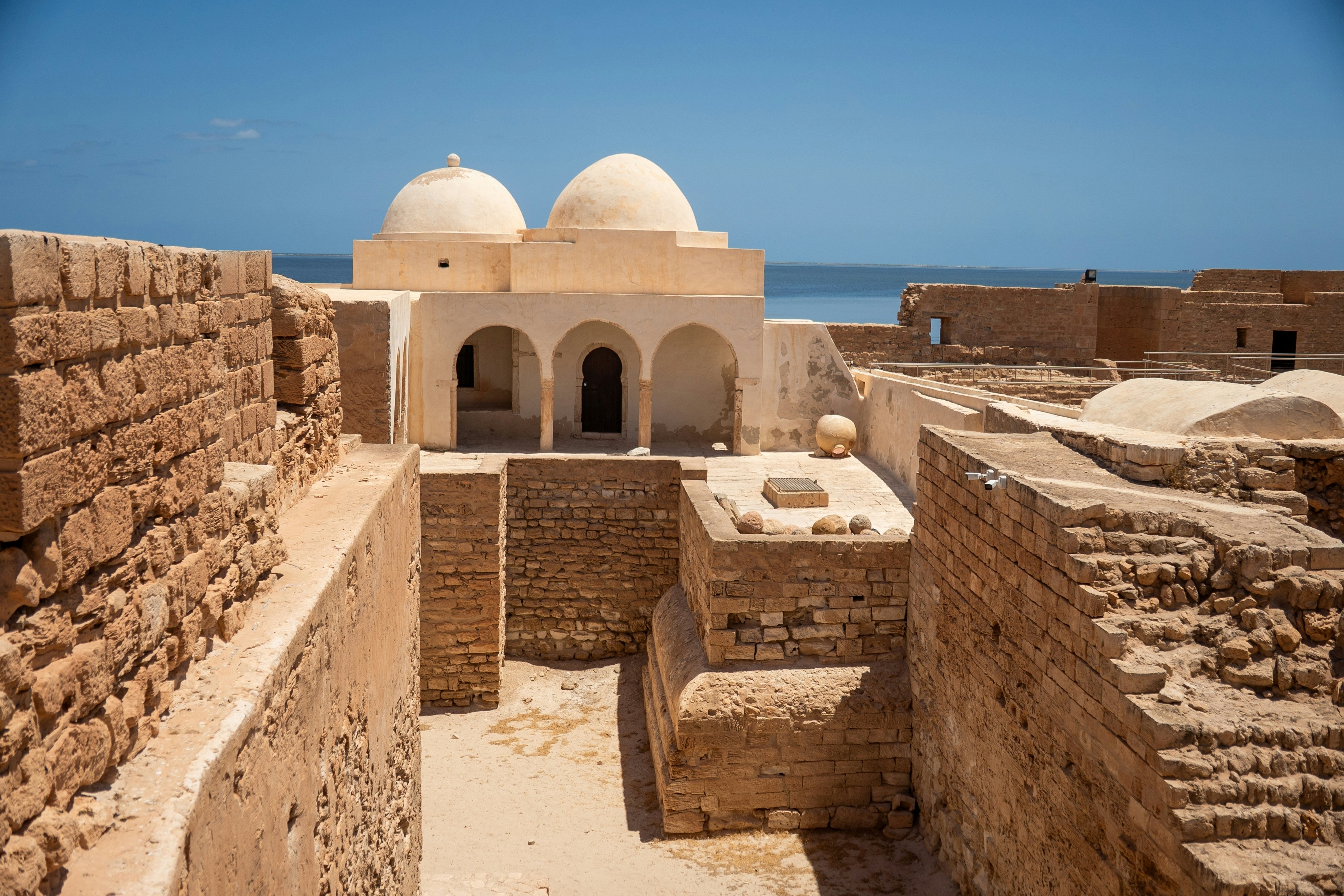 Brick and cement mausoleums with the ocean in the background