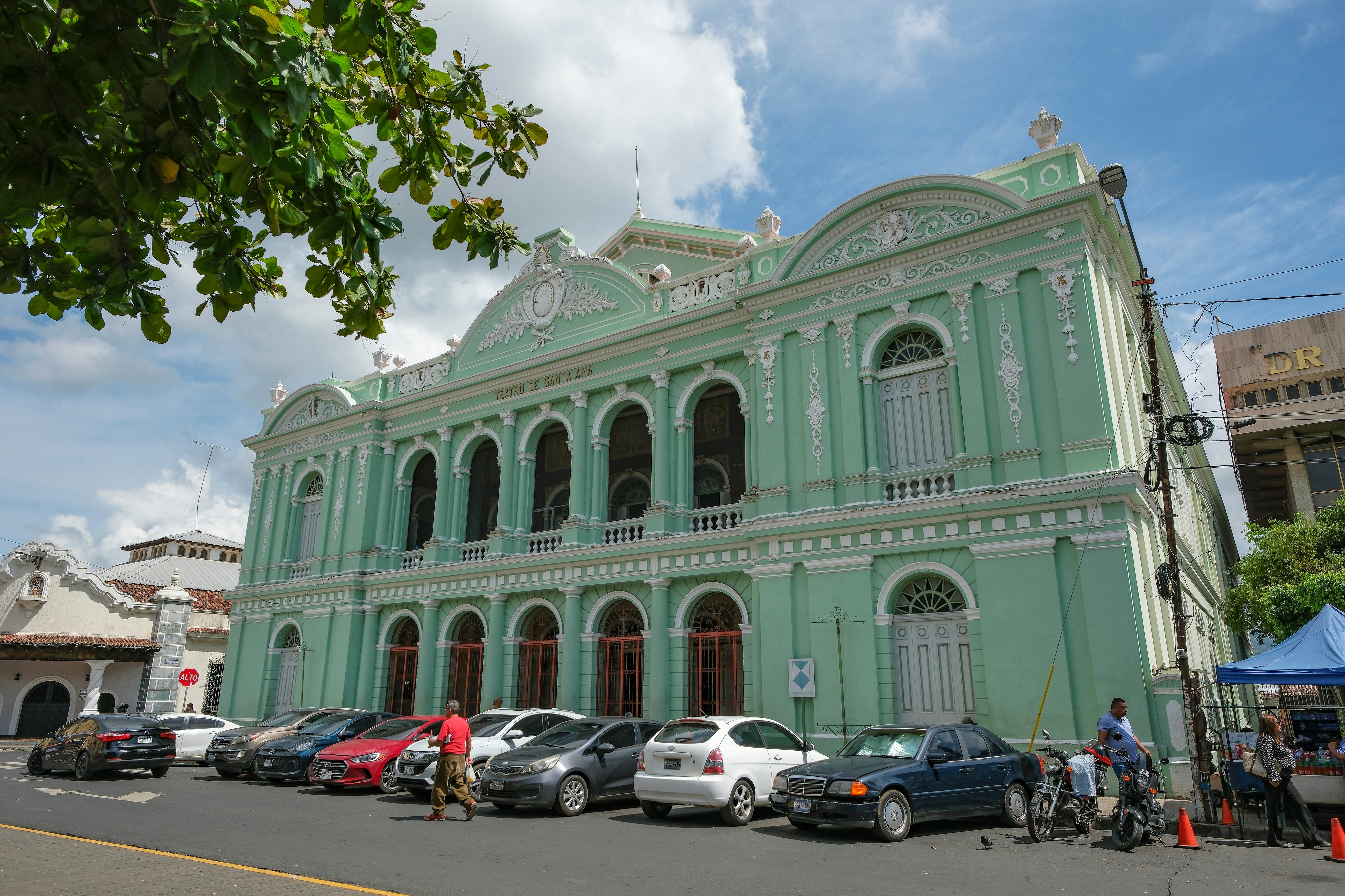 The front of a large, two-level green building with white trim