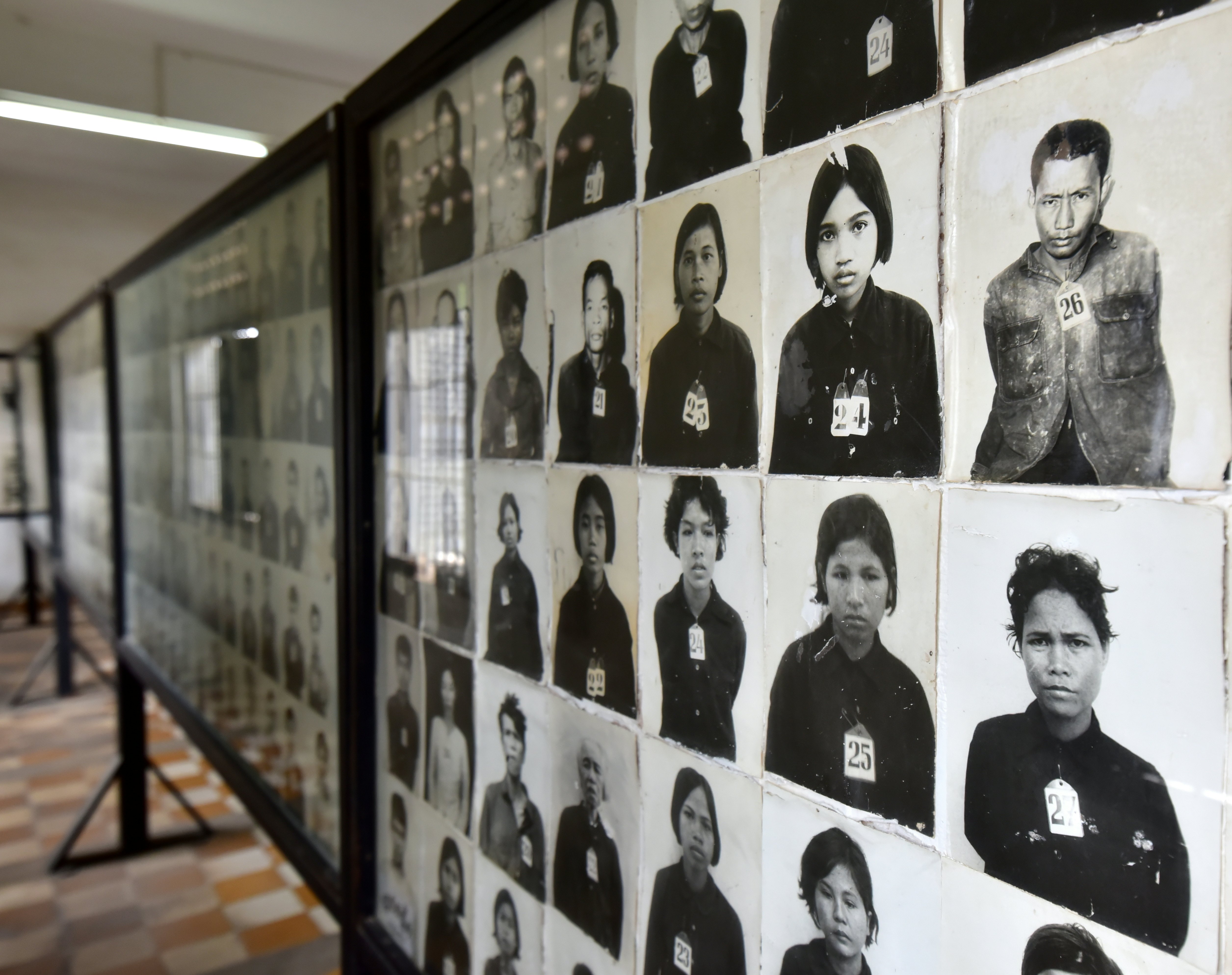 Black-and-white photos of prisoners are displayed at a museum in Cambodia.