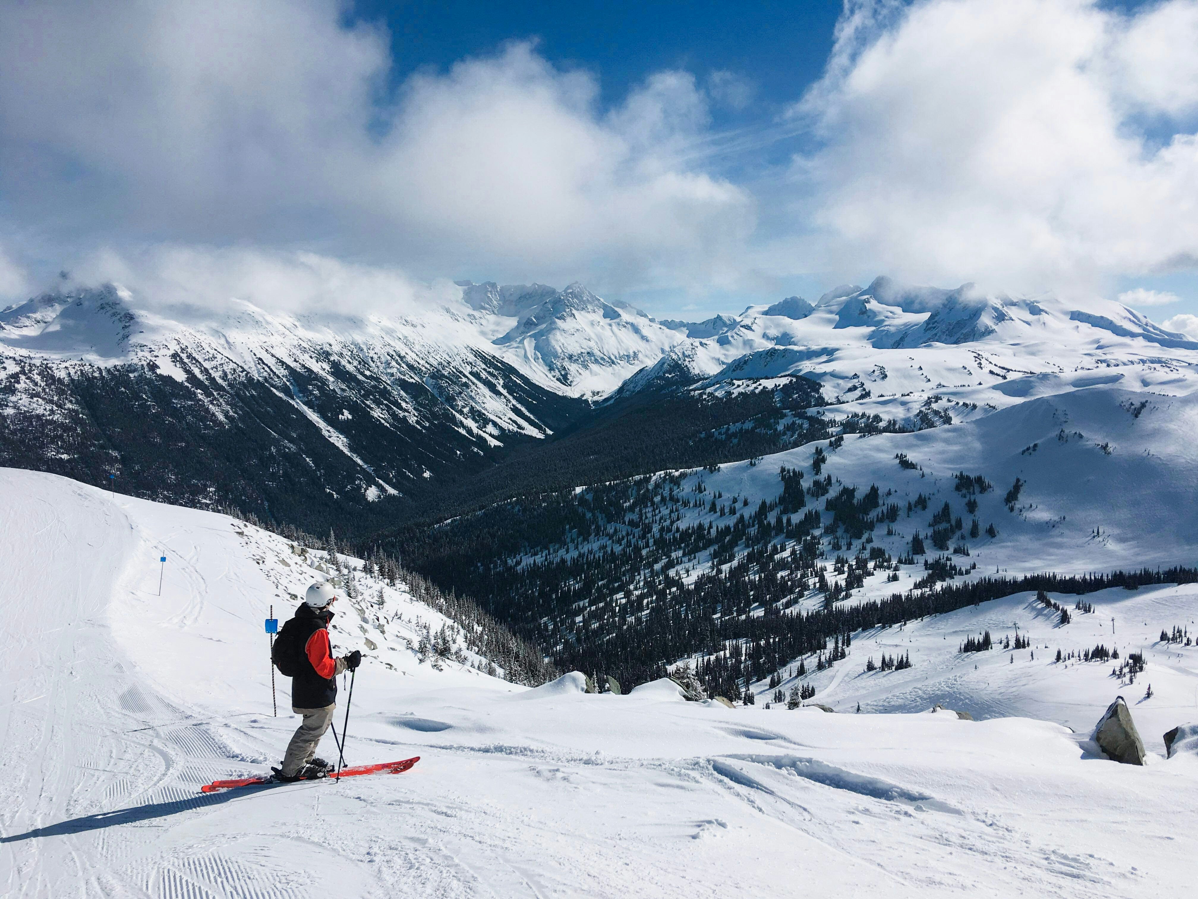 A skier at the top of a run at Whistler, Canada, with a mountain landscape beyond.