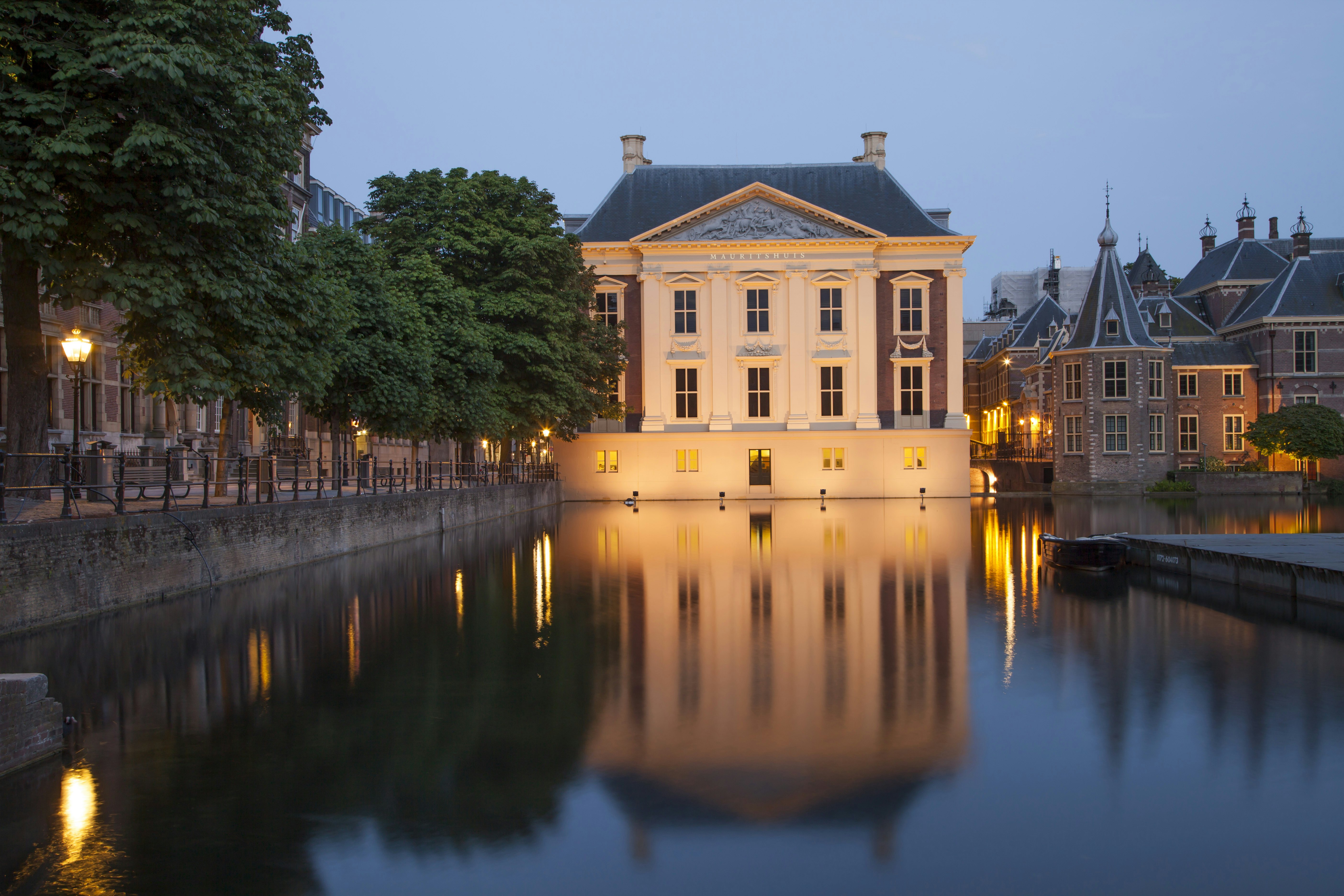 The Mauritshuis Museum at night with the museum's lights reflecting off the local water