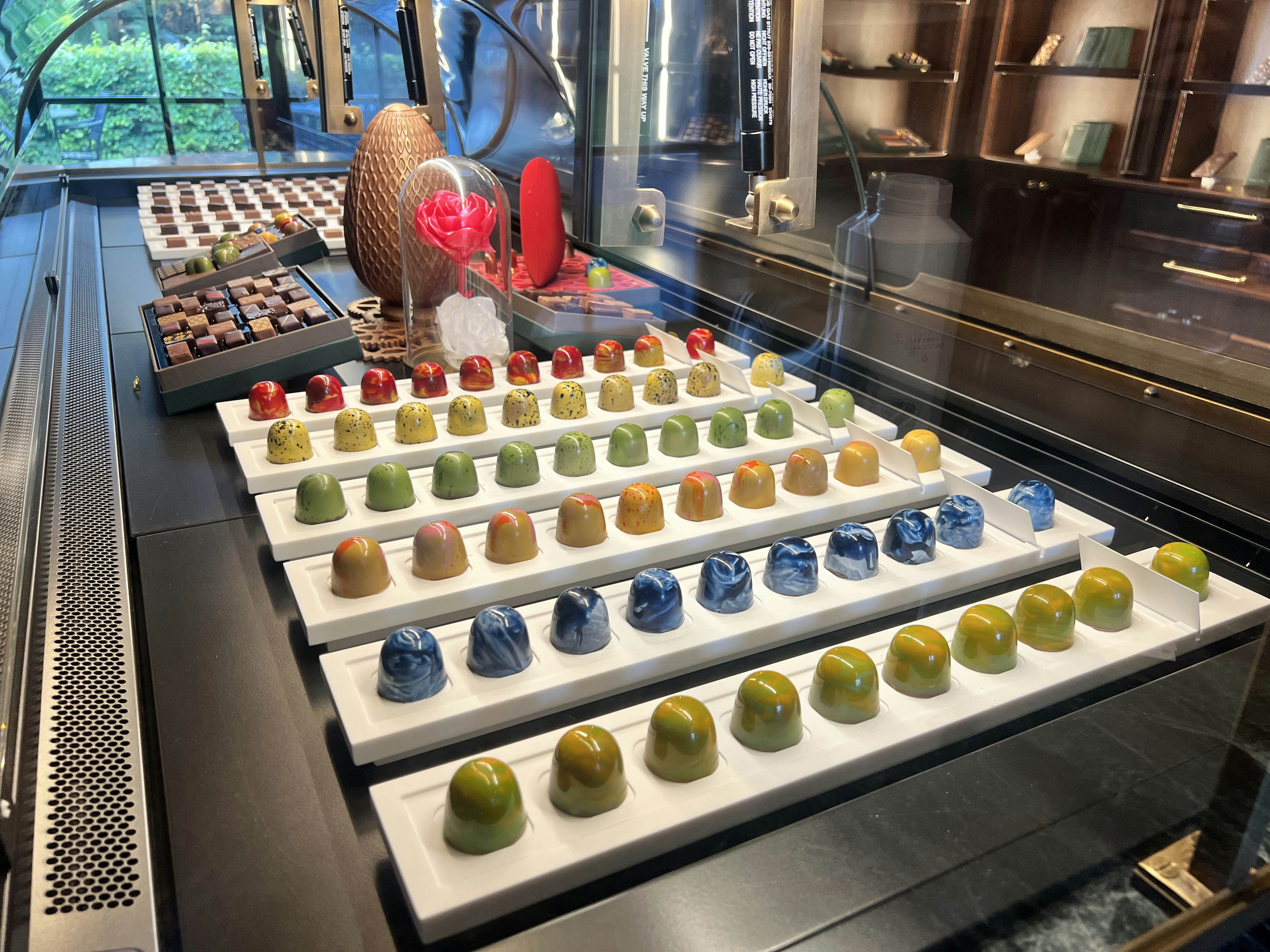 Rows of colorful domed chocolates on a tray.