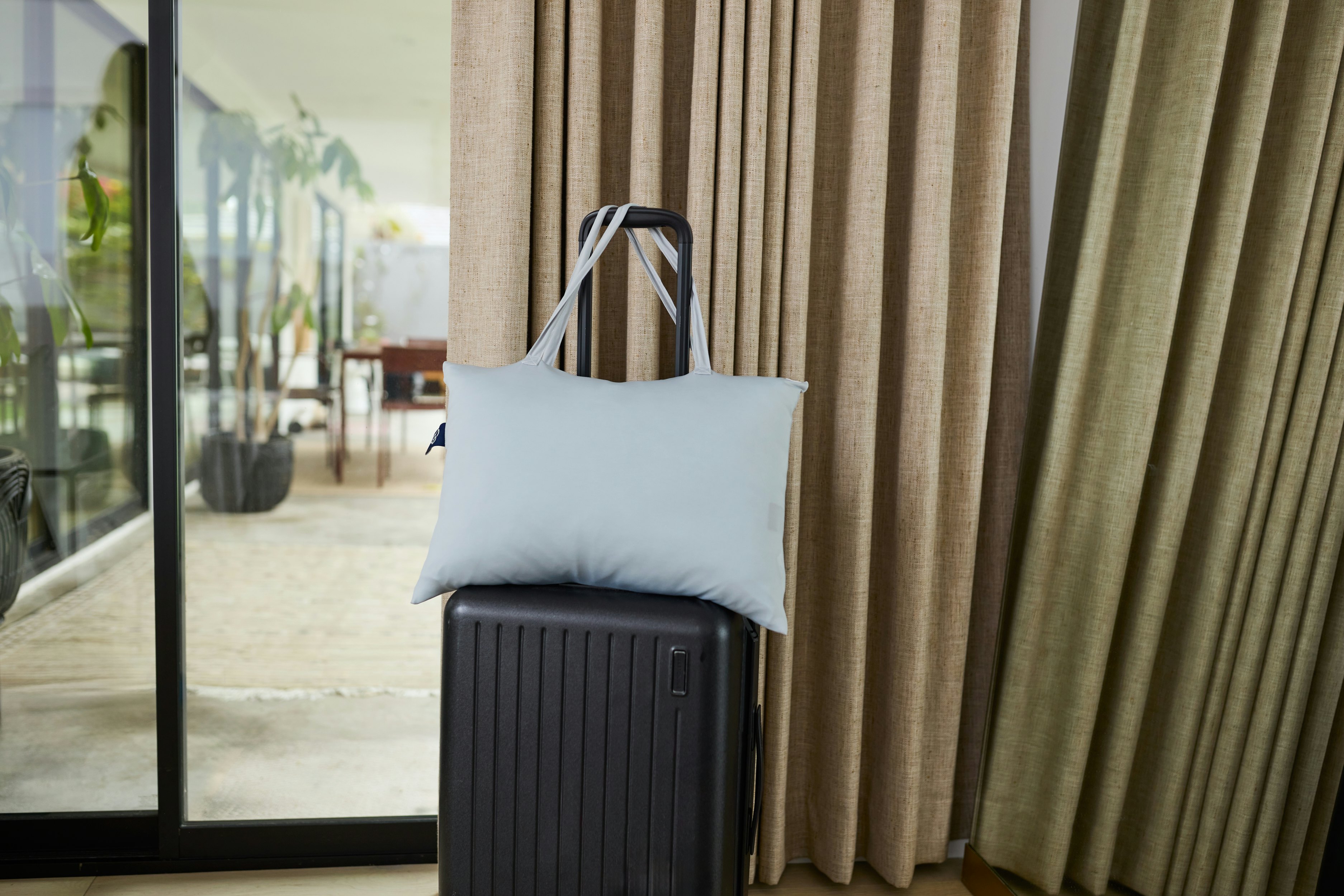 A pillow on top of a suitcase.