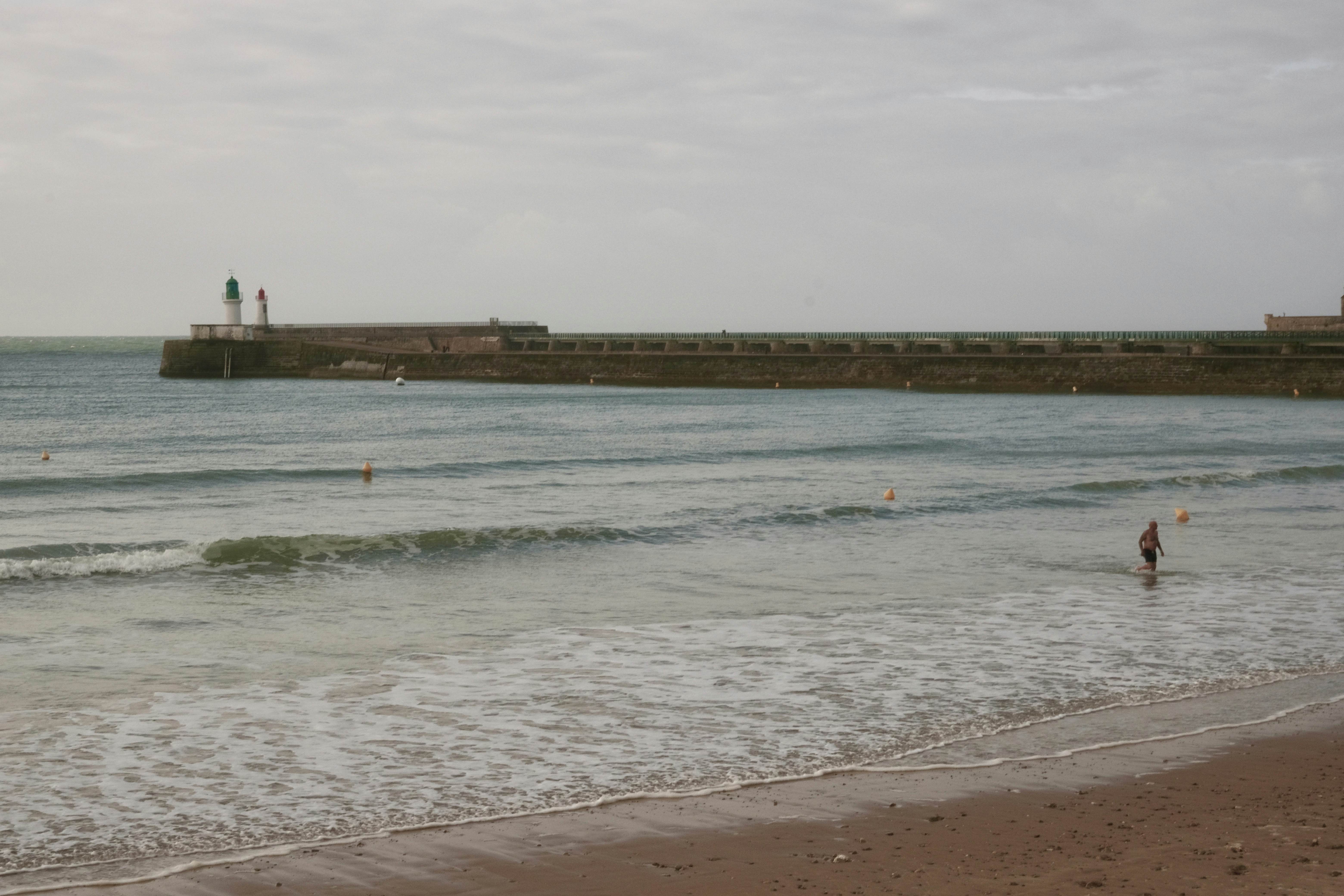 A swimmer walks on the beach in Les Sables d'Olonne.