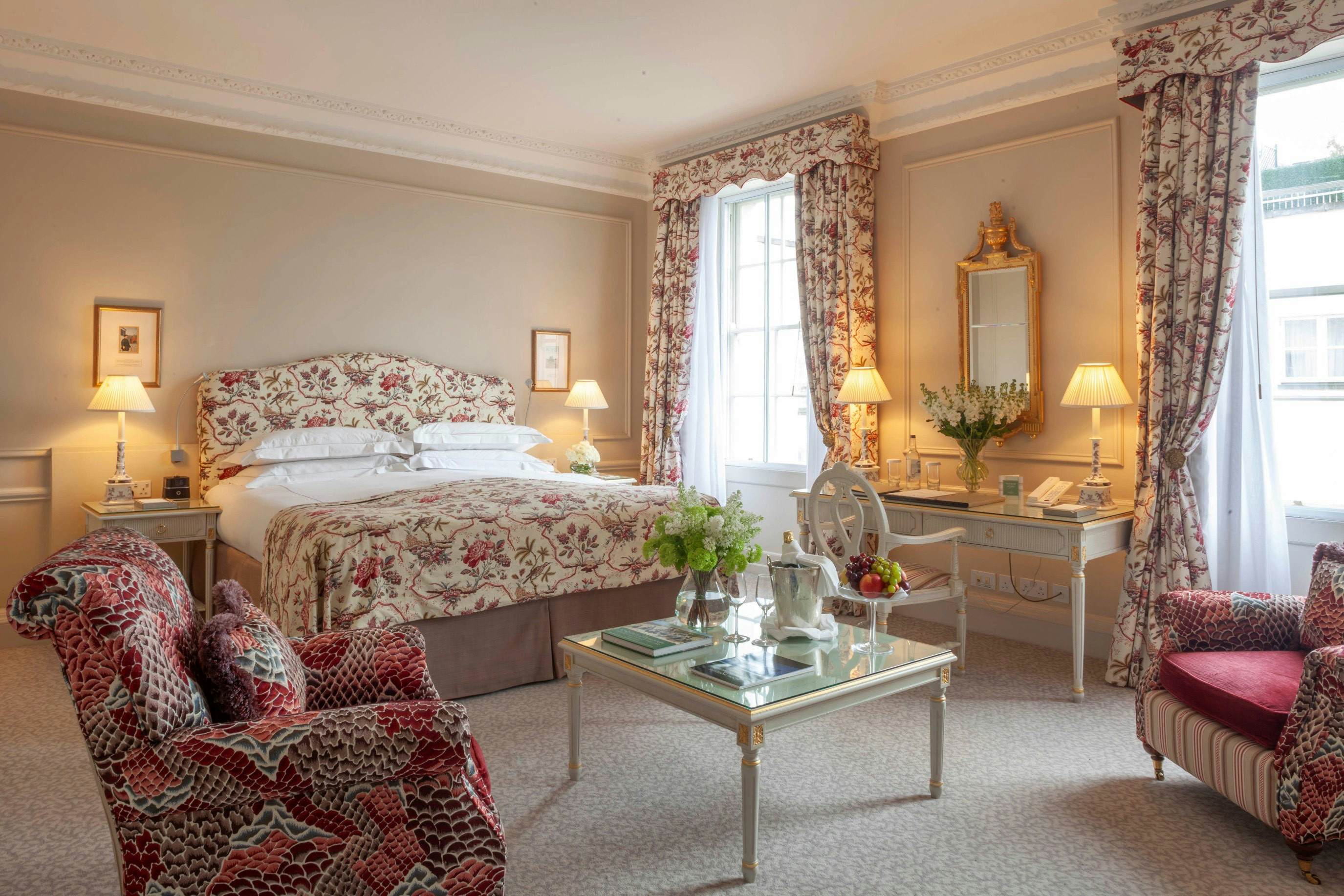 A luxury hotel bedoorm with flower-prints on the bedding and curtains.