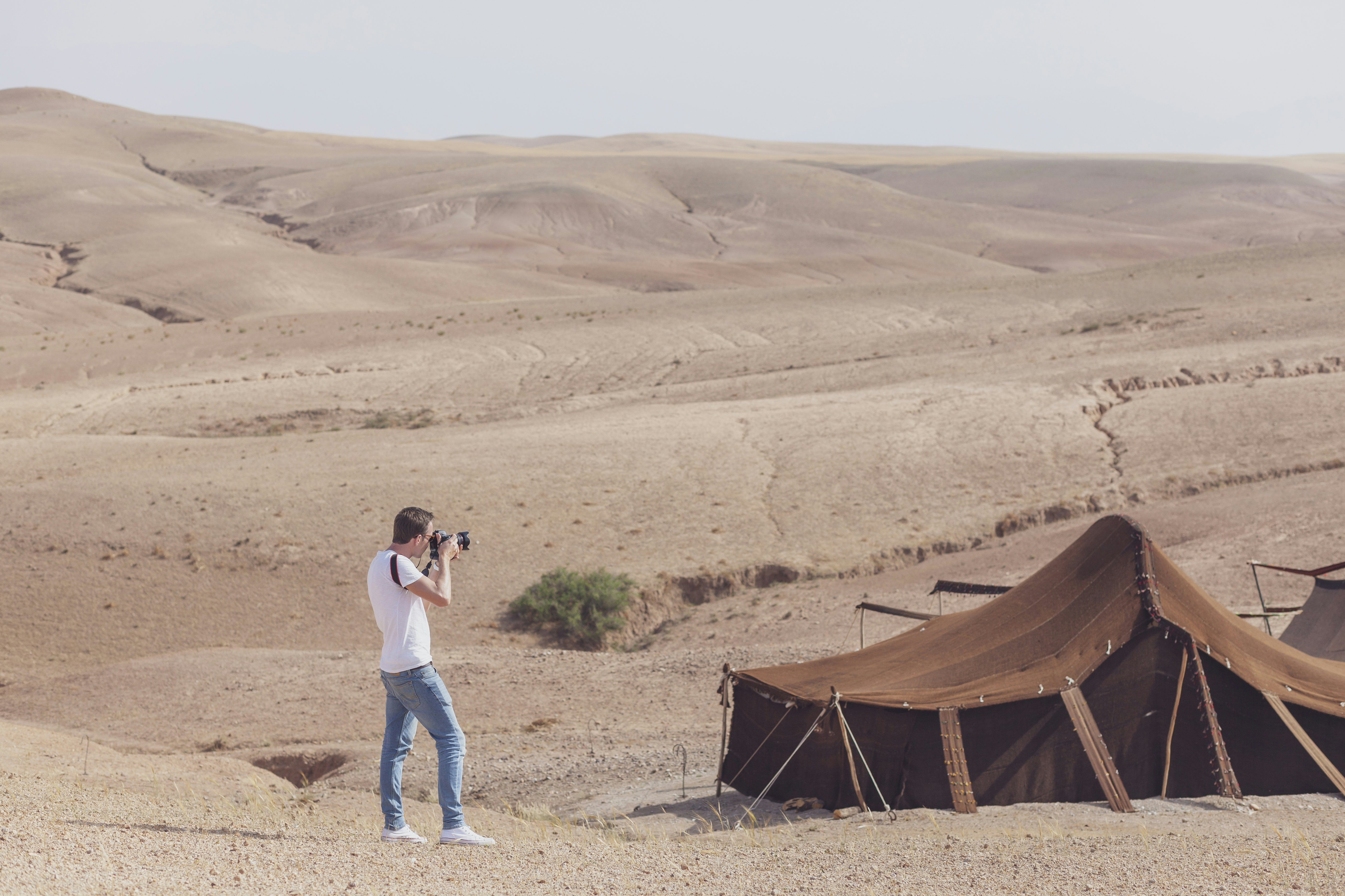 A man photographing tents in the Agafay Desert, Morocco