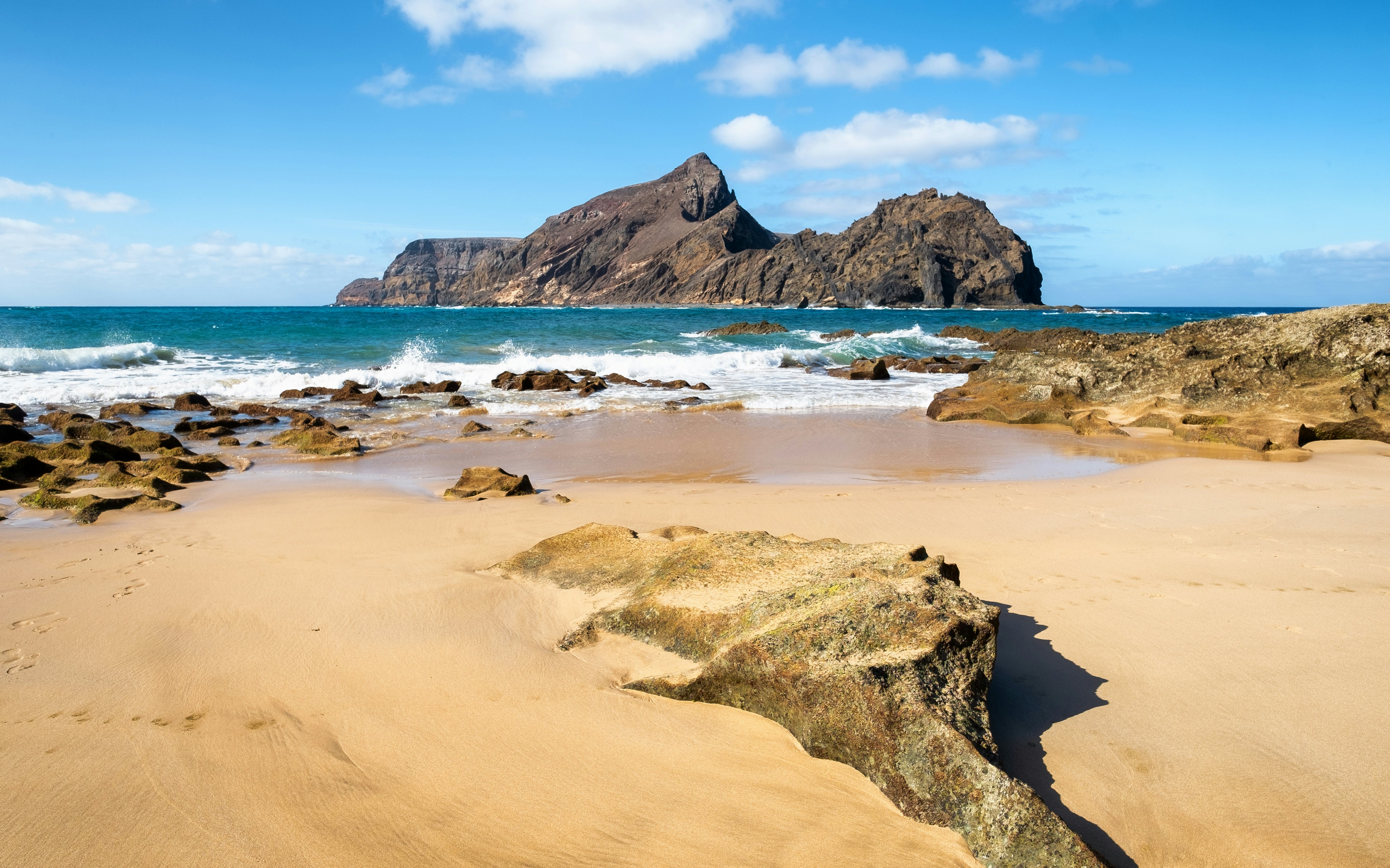 A view across a beach on Porto Santo towards the rocky island of Ilhéu da Cal