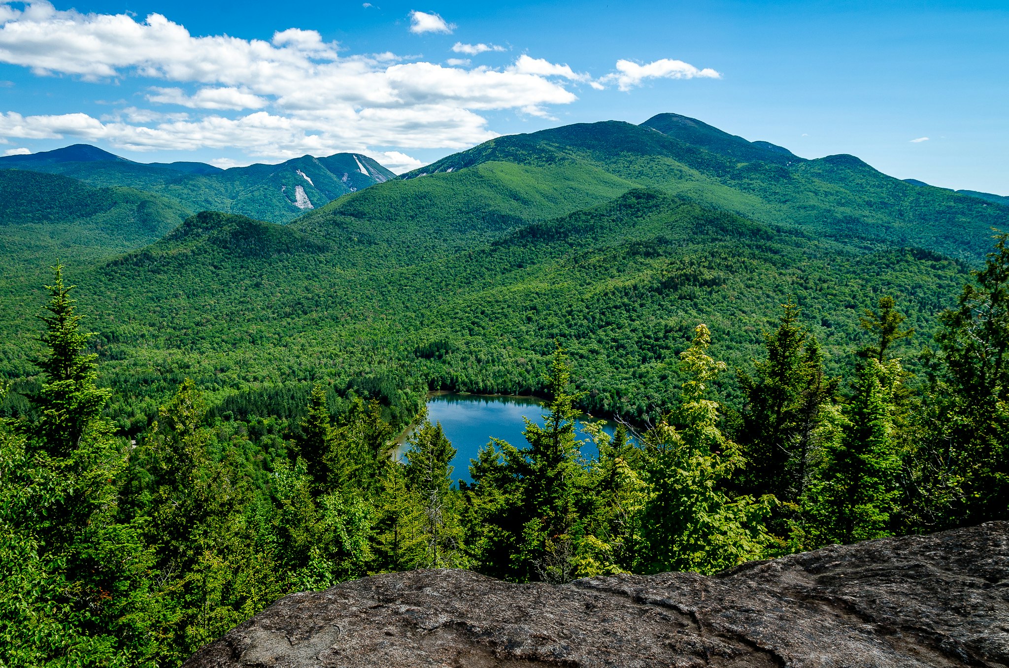 View of green mountains and a small lake